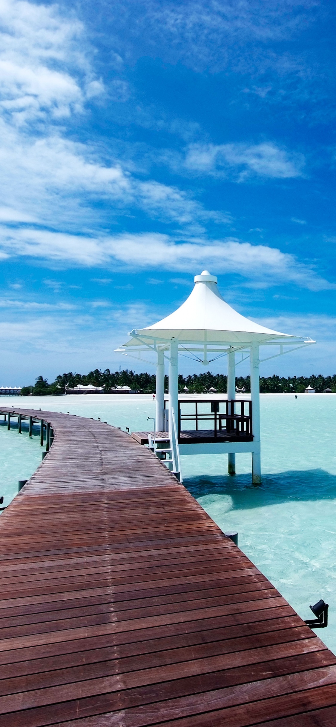 Brown Wooden Dock on Body of Water Under Blue Sky During Daytime. Wallpaper in 1125x2436 Resolution