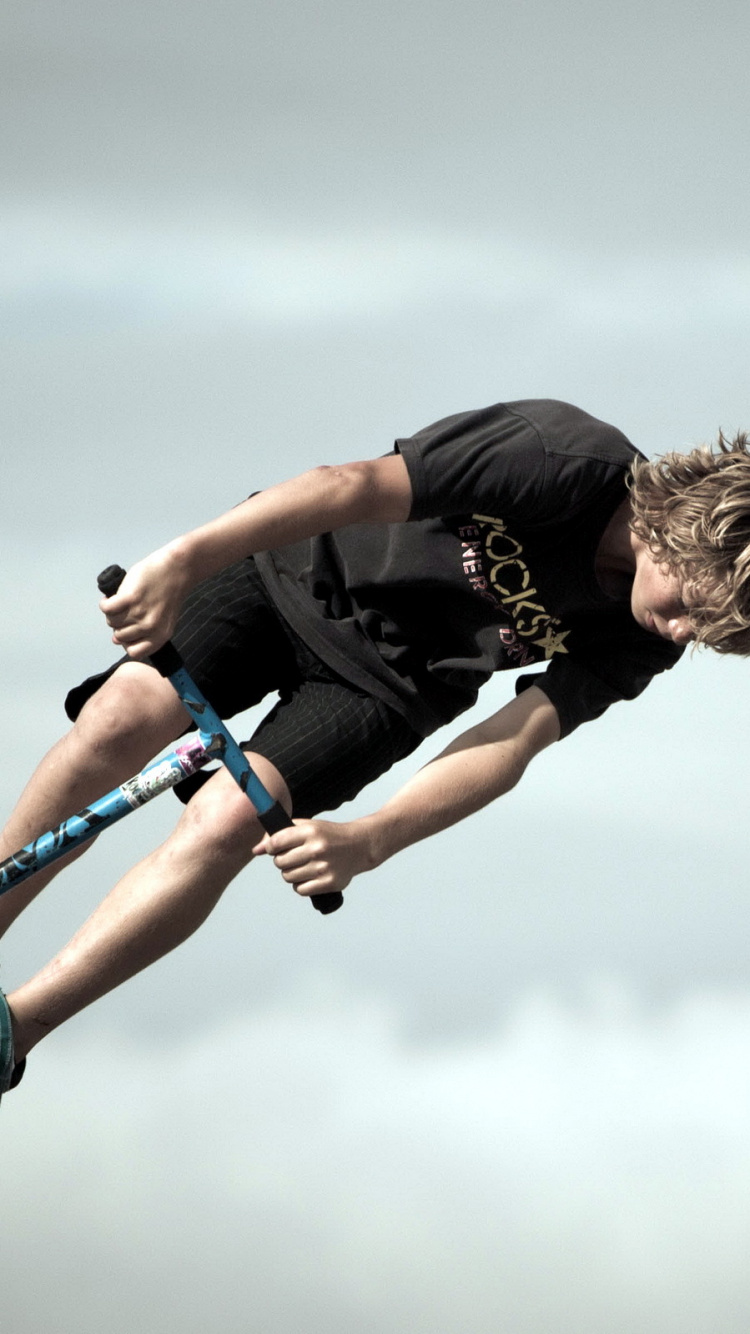 Mann in Schwarzem T-Shirt Und Blauer Denim-Jeans, Der Tagsüber Handstand Macht. Wallpaper in 750x1334 Resolution