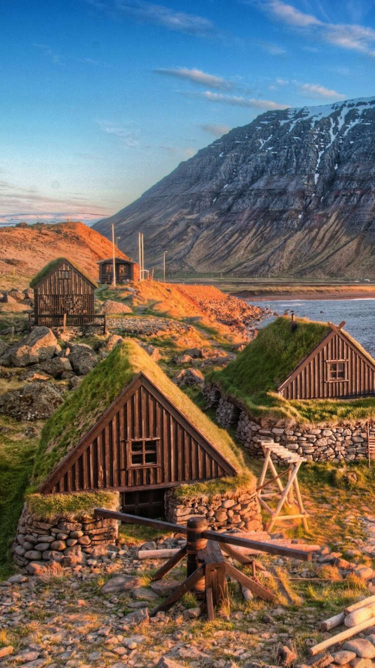 Braunes Holzboot am Ufer in Der Nähe Des Braunen Holzhauses Tagsüber. Wallpaper in 750x1334 Resolution