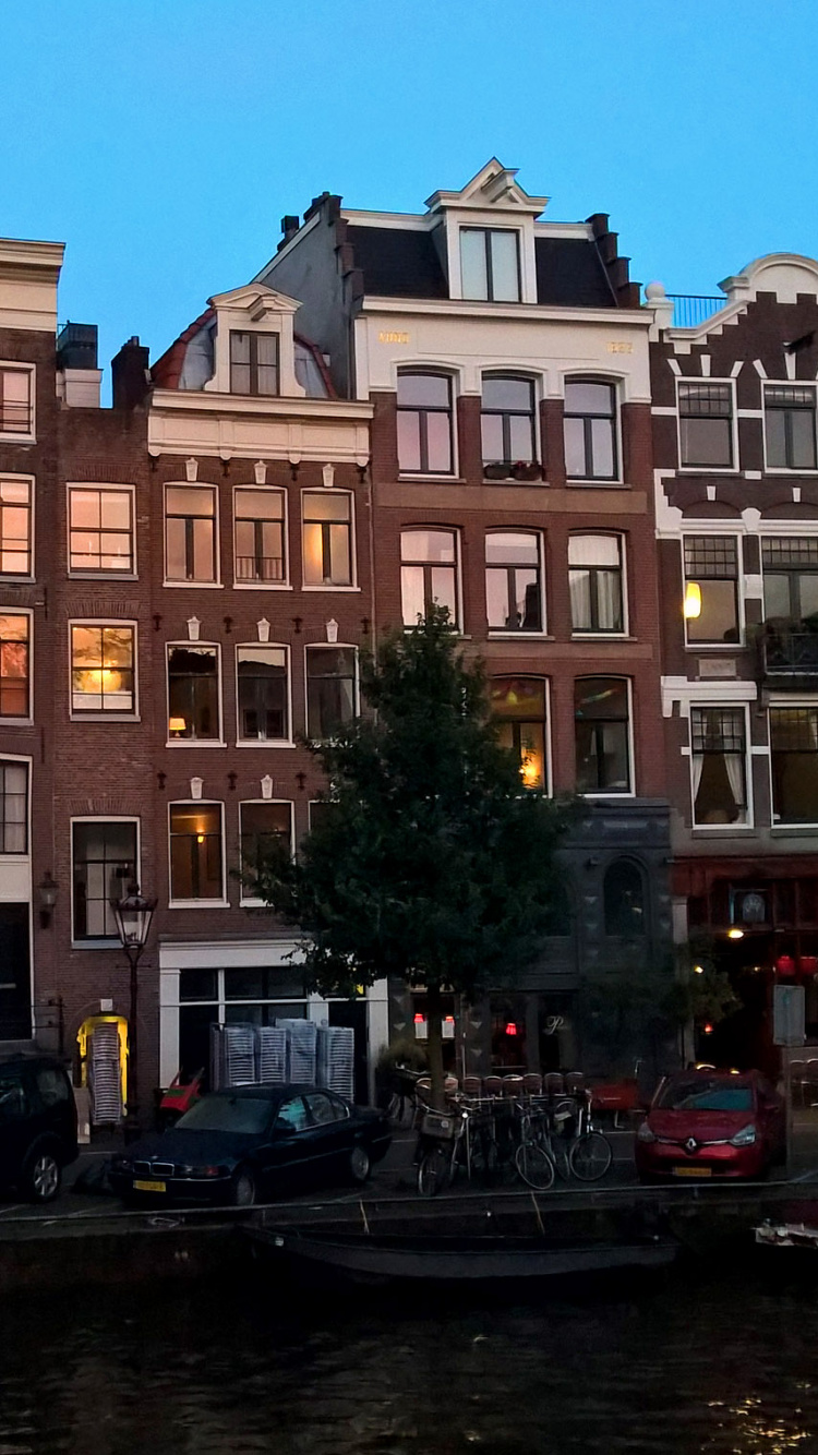 Brown Concrete Building Near Body of Water During Daytime. Wallpaper in 750x1334 Resolution