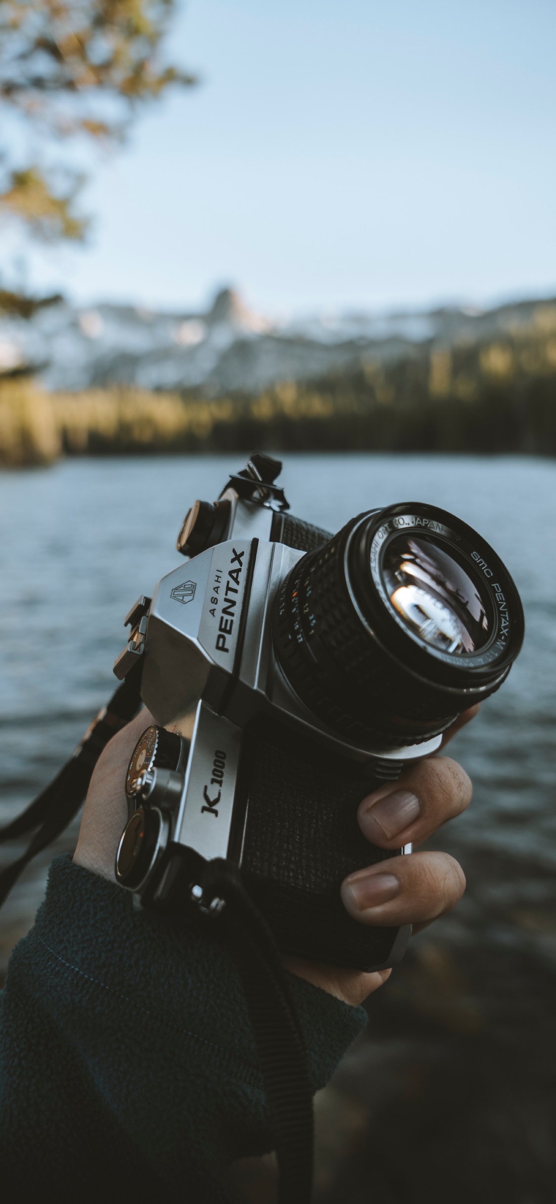 Person Holding Black and Silver Dslr Camera. Wallpaper in 1125x2436 Resolution