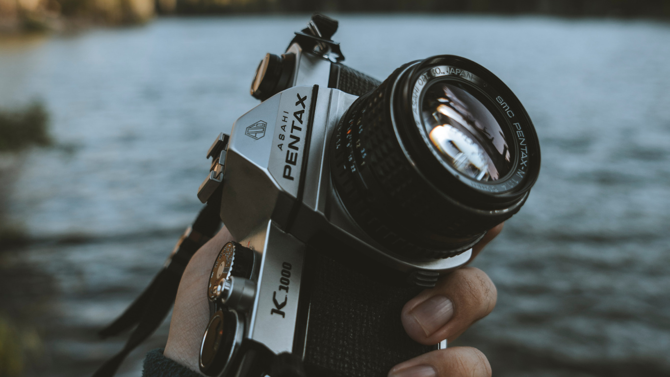 Person Holding Black and Silver Dslr Camera. Wallpaper in 1366x768 Resolution