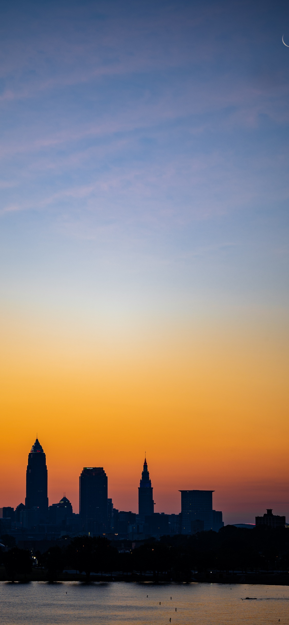 Silhouette Von Stadtgebäuden Bei Sonnenuntergang. Wallpaper in 1125x2436 Resolution