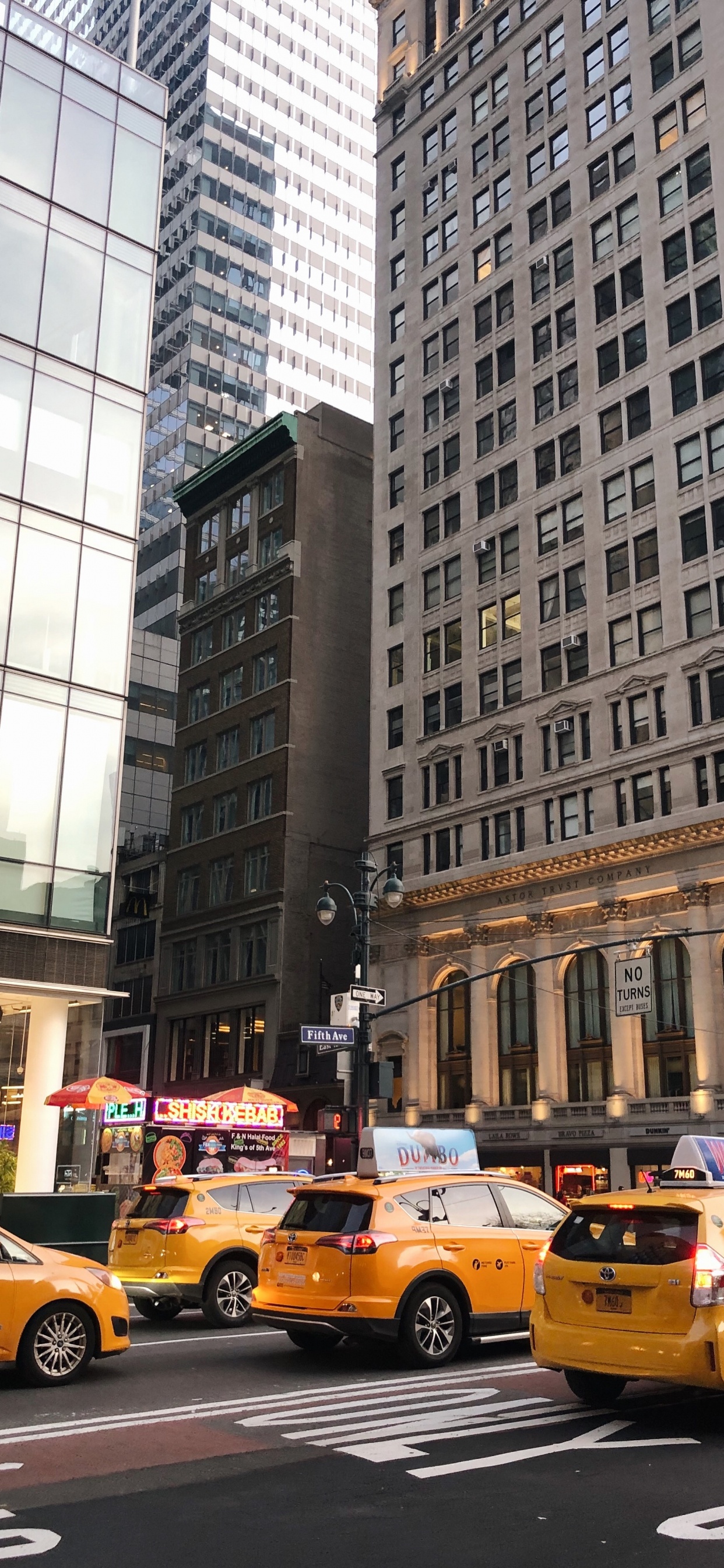 Gelbes Taxi Auf Der Straße in Der Nähe Des Hochhauses Tagsüber. Wallpaper in 1242x2688 Resolution