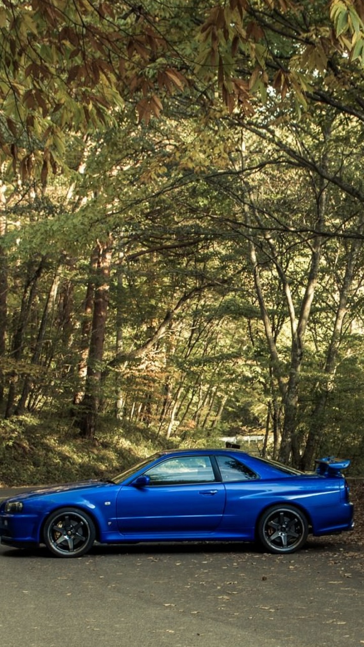 Blue Coupe on Road Between Trees During Daytime. Wallpaper in 720x1280 Resolution