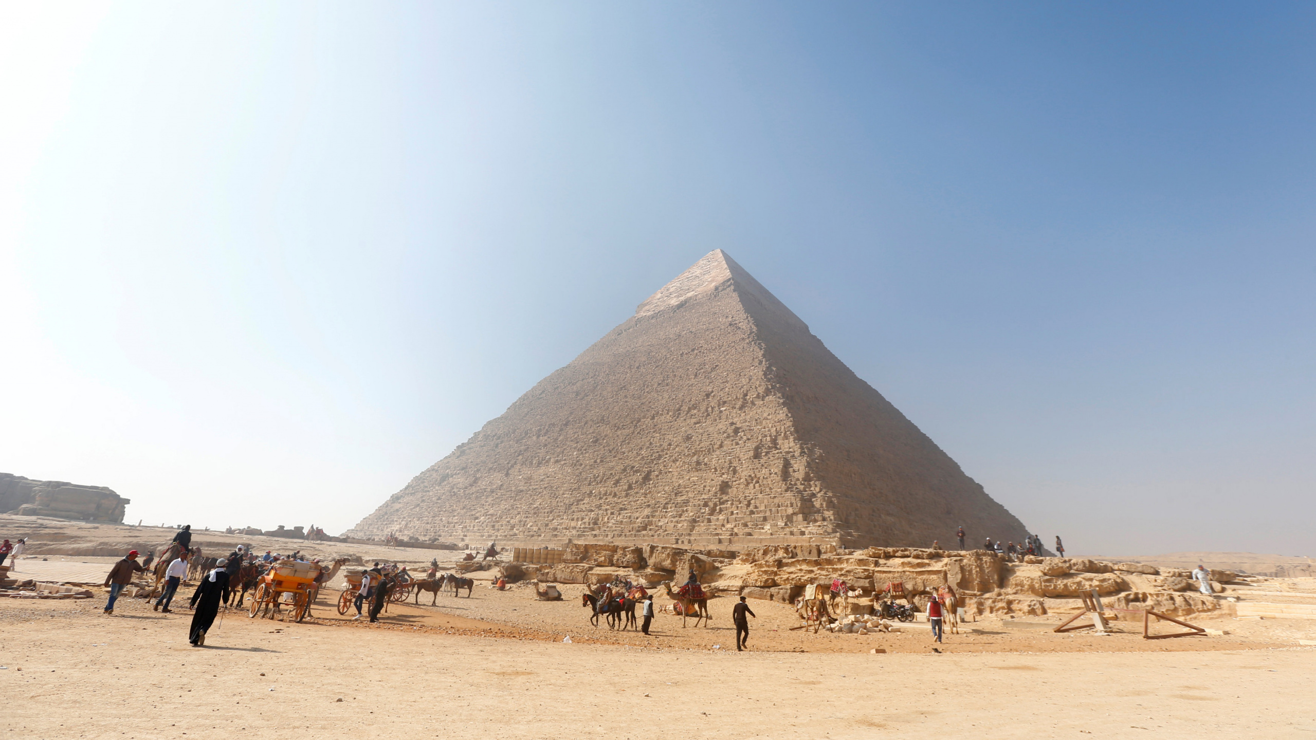 People on Brown Sand Near Pyramid Under Blue Sky During Daytime. Wallpaper in 2560x1440 Resolution