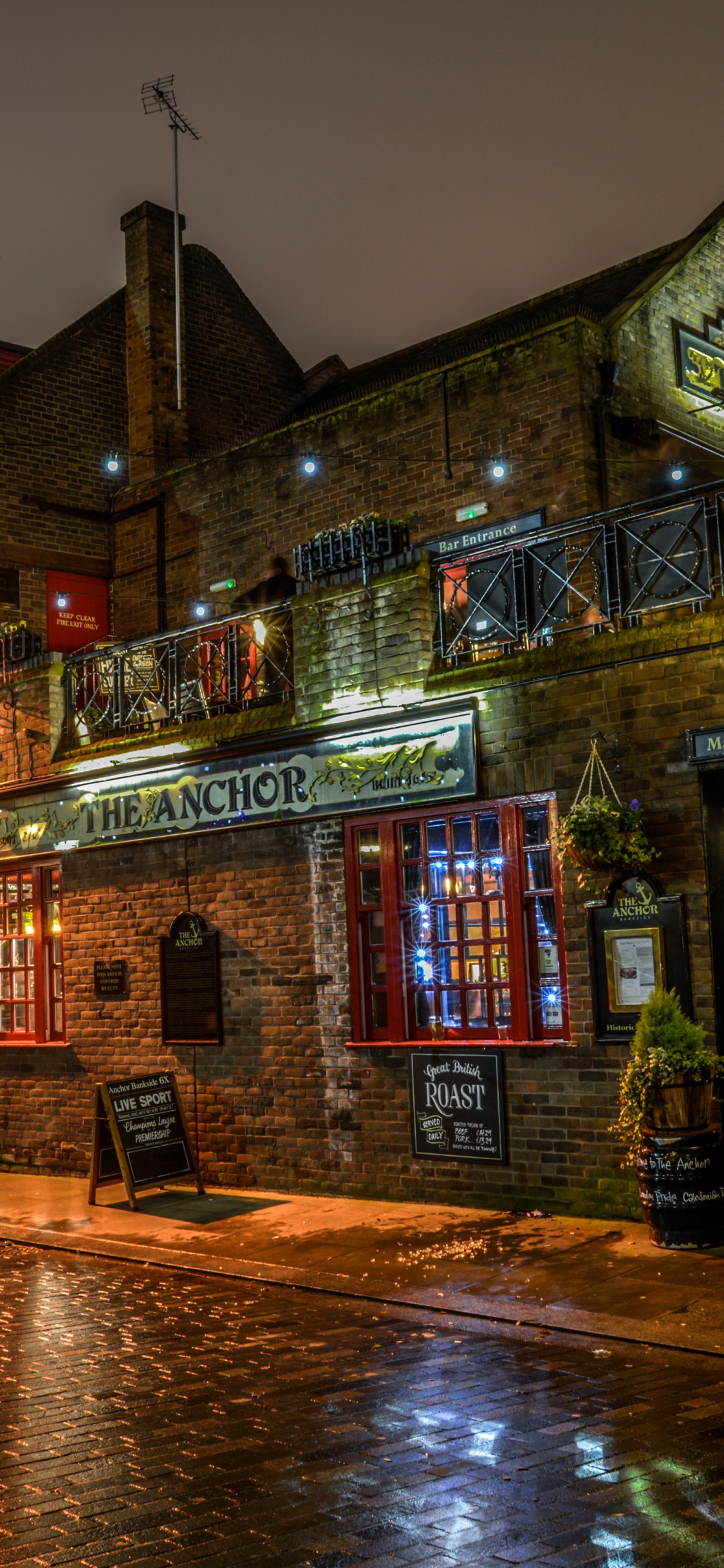 Braunes Und Beiges Betongebäude Während Der Nacht. Wallpaper in 1125x2436 Resolution