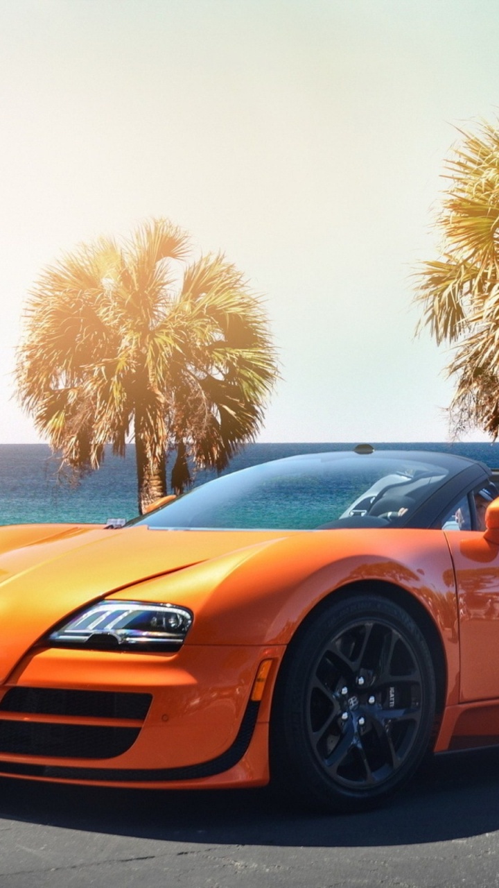 Orange Ferrari 458 Italia Parked on Gray Concrete Pavement Near Palm Trees During Daytime. Wallpaper in 720x1280 Resolution