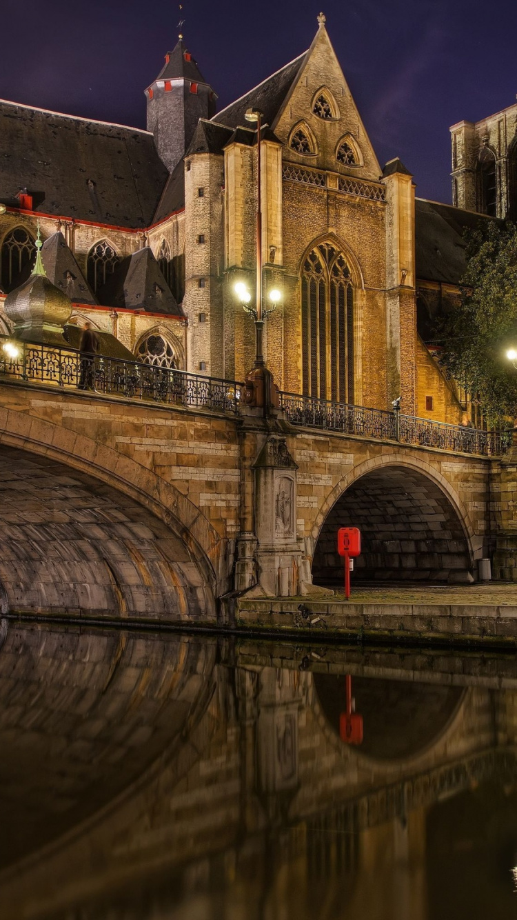 Brown Concrete Building Near River During Night Time. Wallpaper in 750x1334 Resolution