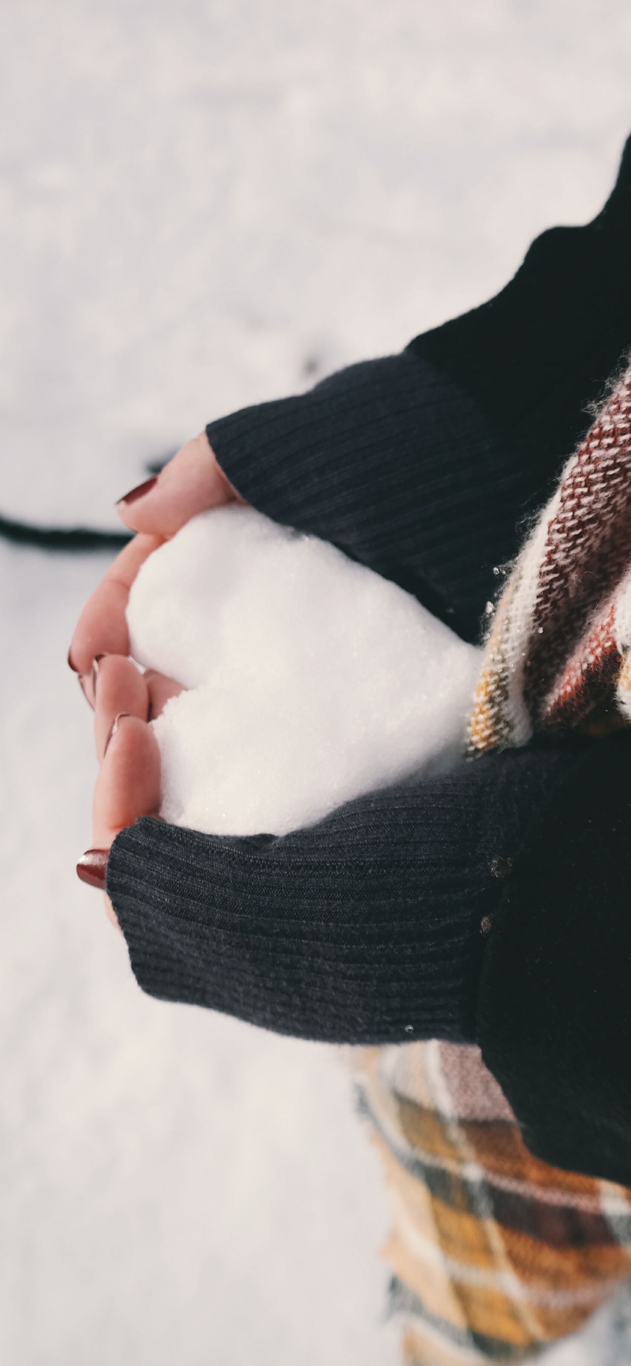 Person in Black Sweater Holding Brown and White Scarf. Wallpaper in 1242x2688 Resolution