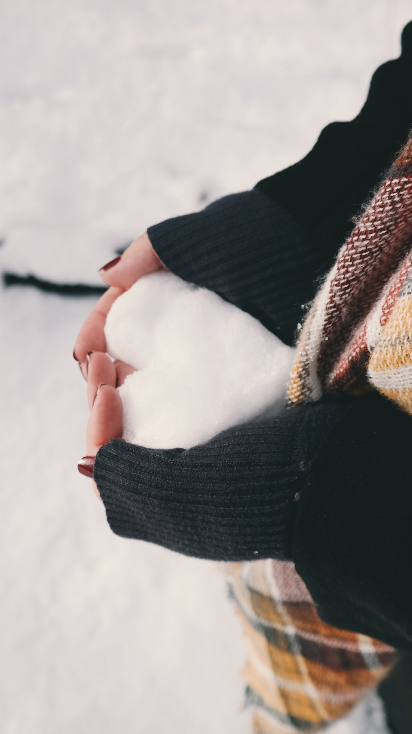 Person in Black Sweater Holding Brown and White Scarf. Wallpaper in 1440x2560 Resolution
