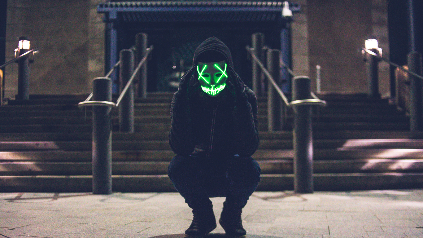 Person im Schwarzen Hoodie Mit Grüner Maske. Wallpaper in 1366x768 Resolution