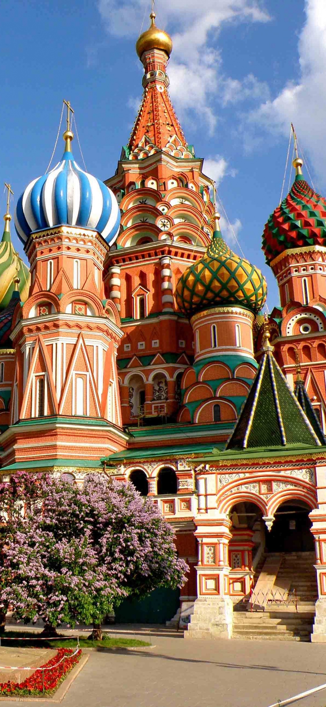 Edificio de Hormigón Marrón y Verde Bajo un Cielo Azul Durante el Día. Wallpaper in 1125x2436 Resolution