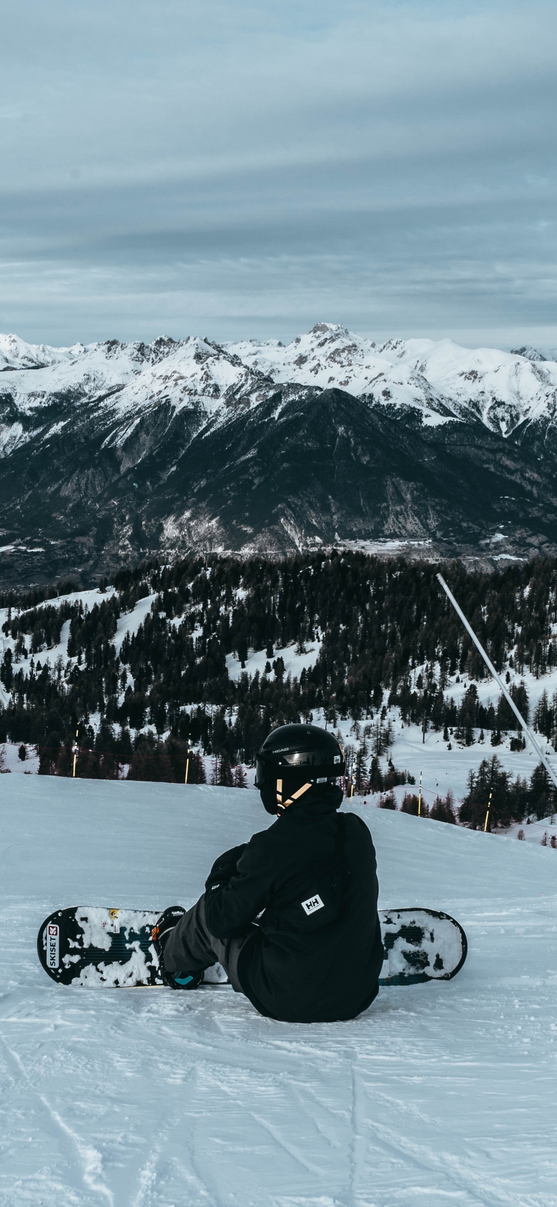 Man in Black Jacket Riding Sur Moto Noire Sur la Montagne Couverte de Neige Pendant la Journée. Wallpaper in 1125x2436 Resolution