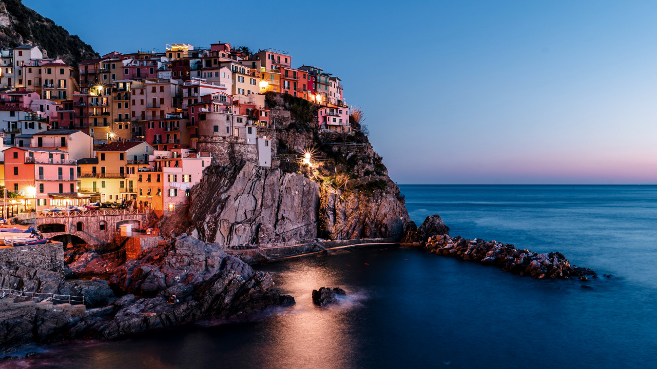 Edificio de Hormigón Marrón Cerca Del Cuerpo de Agua Durante el Día. Wallpaper in 1280x720 Resolution