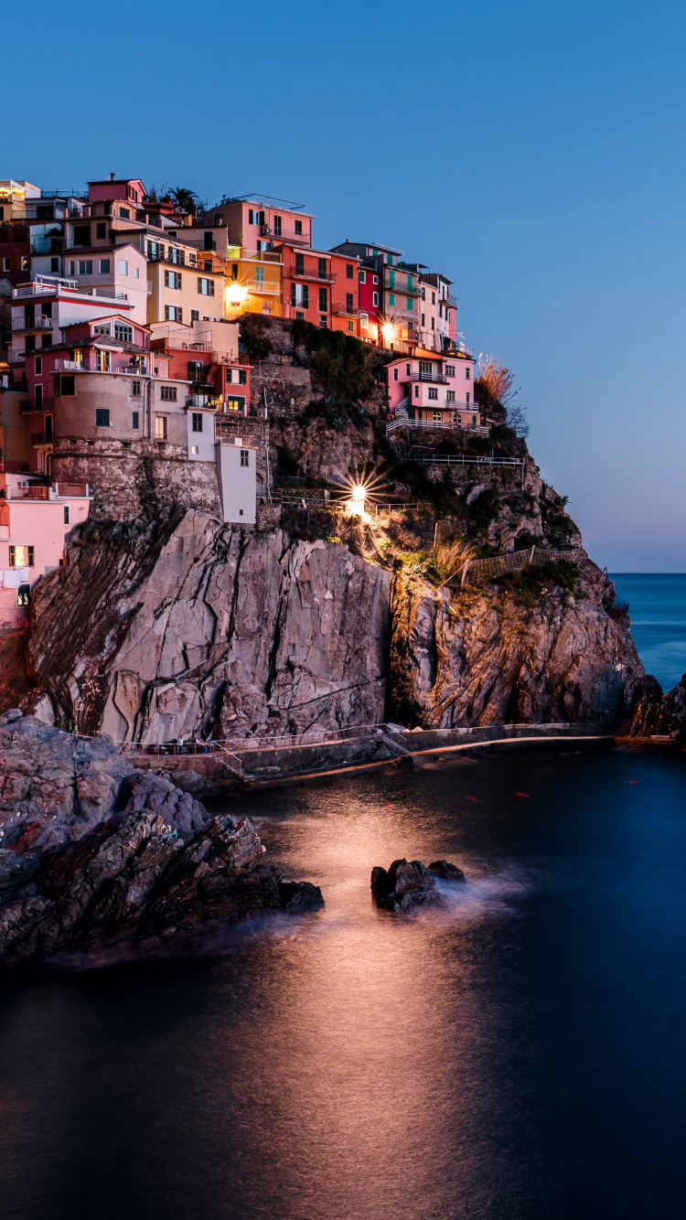 Edificio de Hormigón Marrón Cerca Del Cuerpo de Agua Durante el Día. Wallpaper in 750x1334 Resolution