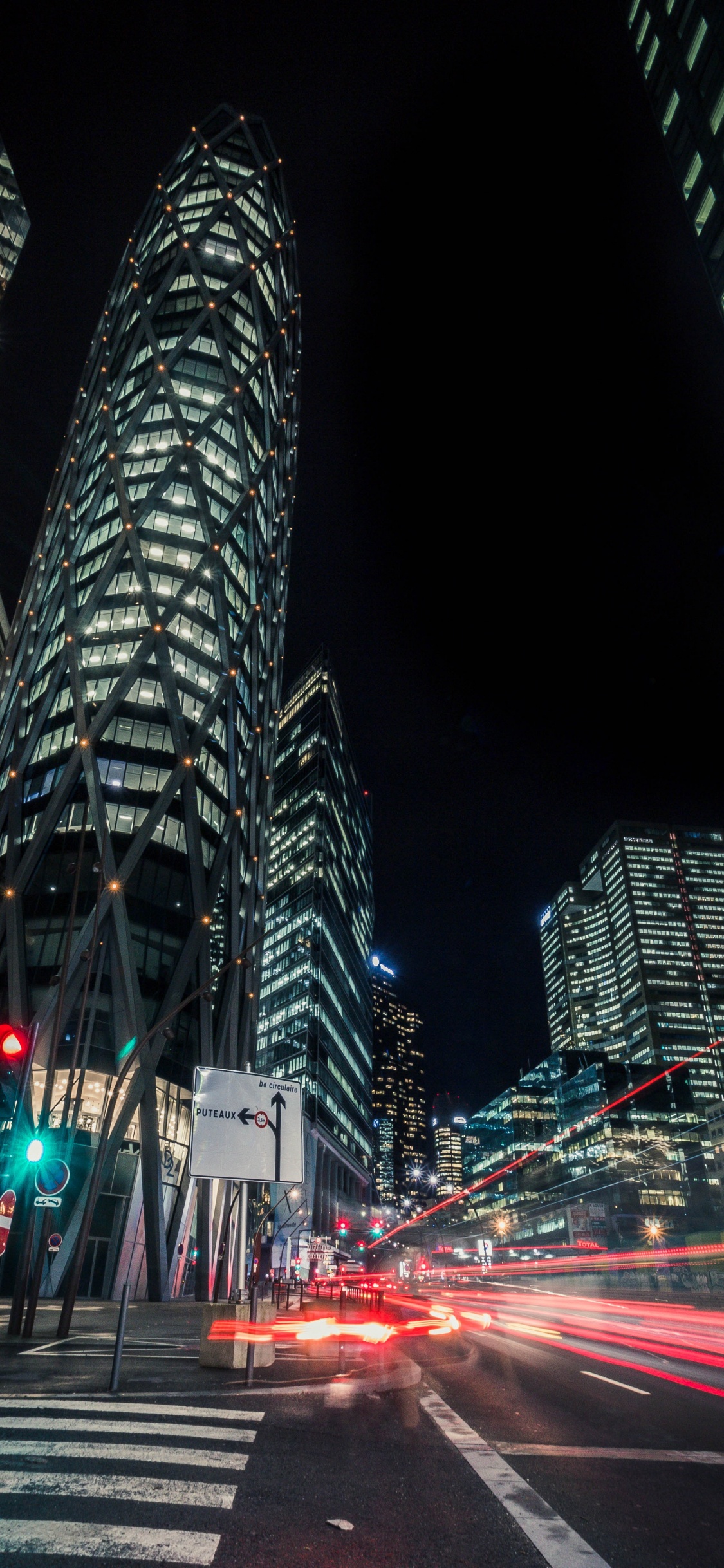 Cars on Road Near High Rise Building During Night Time. Wallpaper in 1125x2436 Resolution