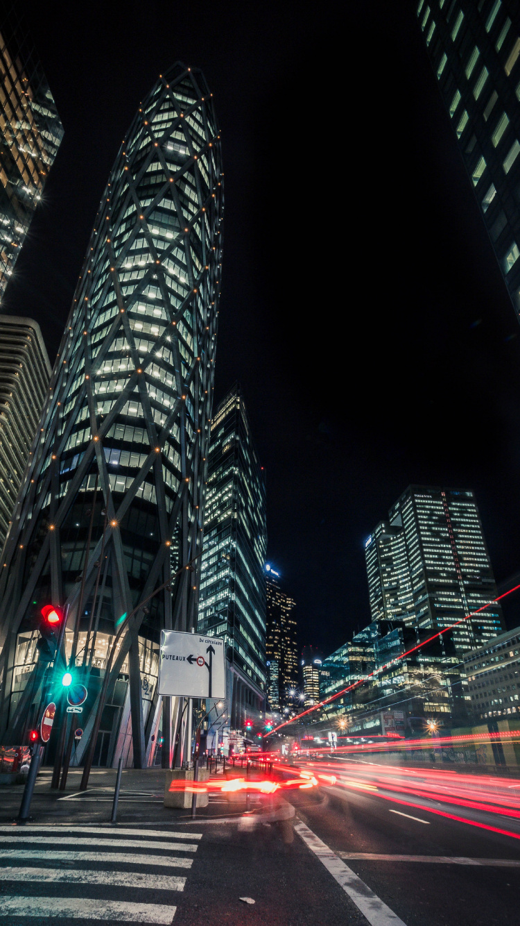 Voitures Sur Route Près D'un Immeuble de Grande Hauteur Pendant la Nuit. Wallpaper in 750x1334 Resolution