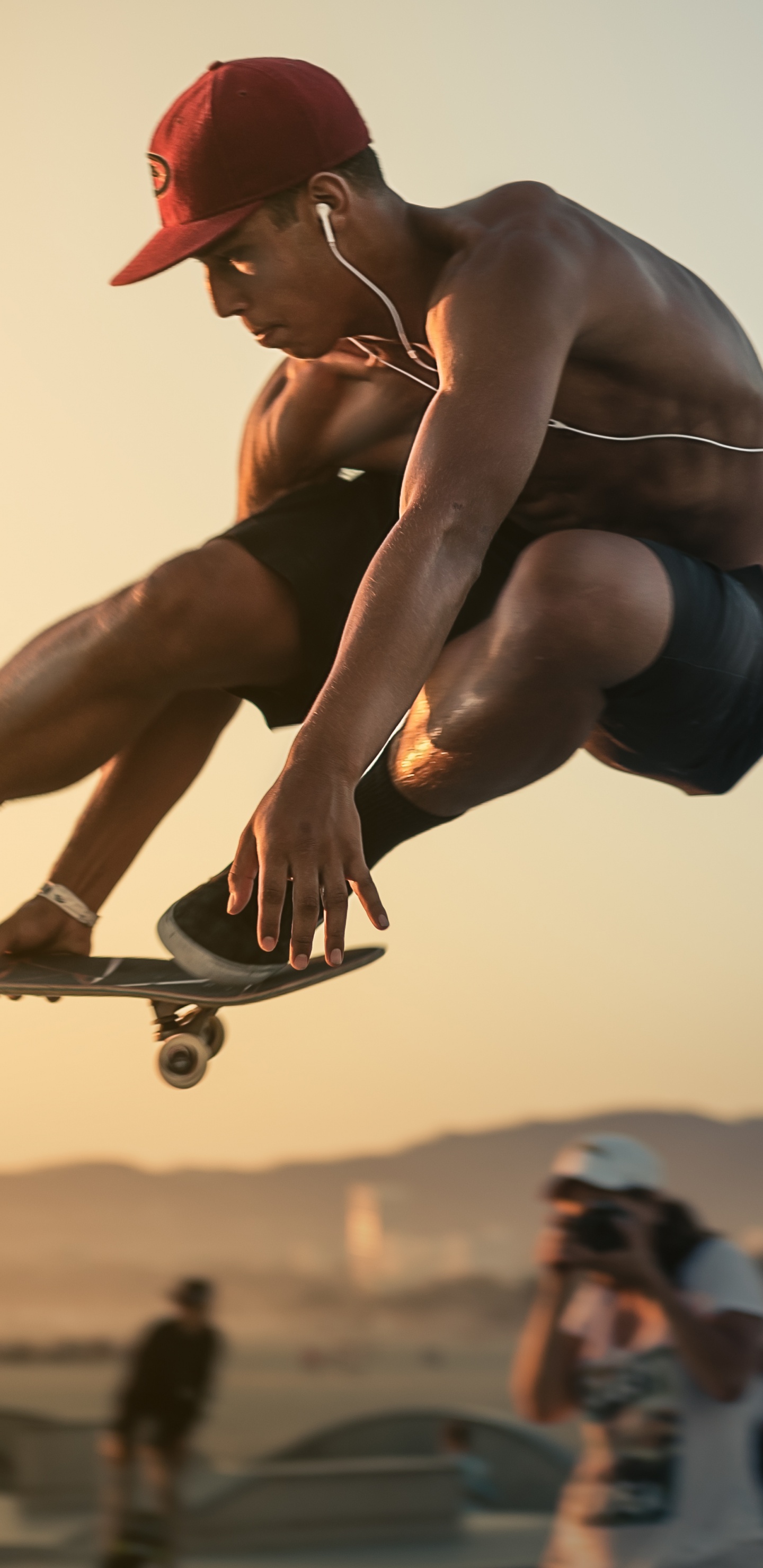 Man in Red Cap and Blue Shorts Doing Stunts. Wallpaper in 1440x2960 Resolution