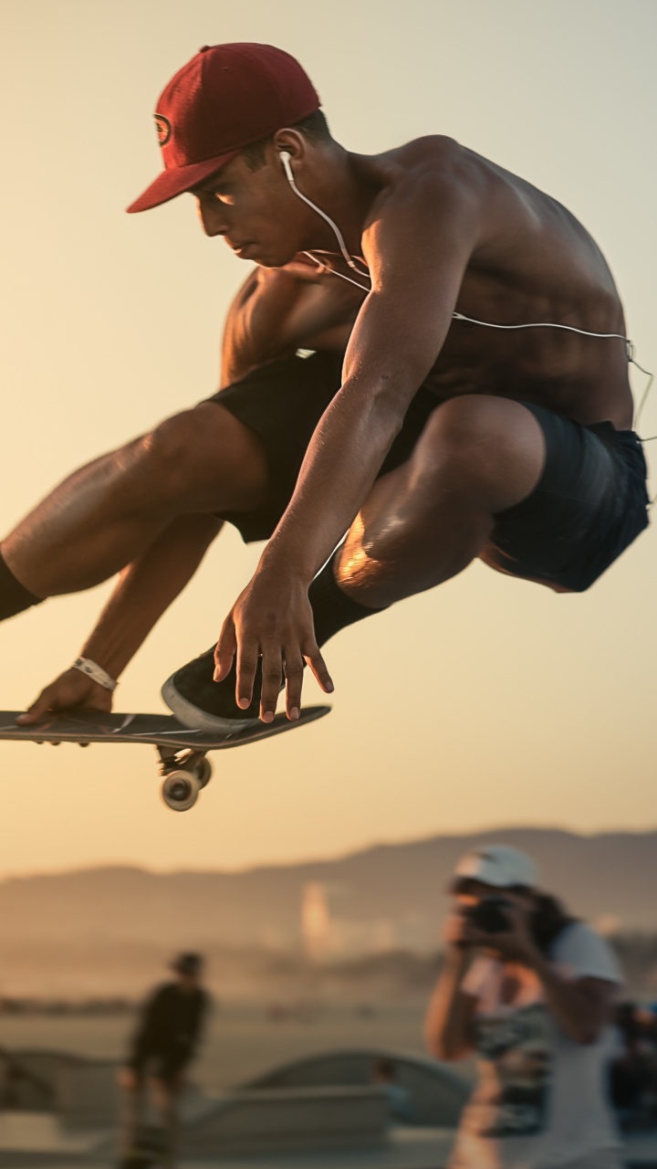 Man in Red Cap and Blue Shorts Doing Stunts. Wallpaper in 720x1280 Resolution