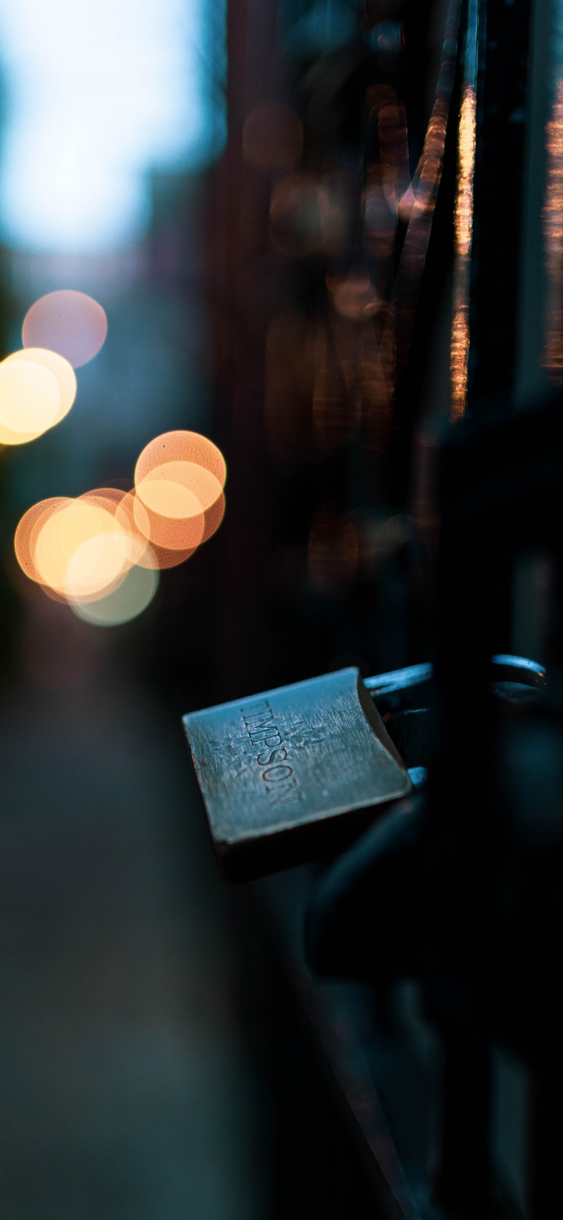 Grey Padlock on Black Metal Fence During Night Time. Wallpaper in 1125x2436 Resolution