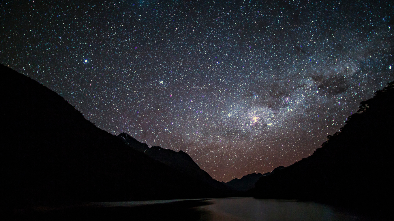 Body of Water Near Mountain Under Starry Night. Wallpaper in 1366x768 Resolution