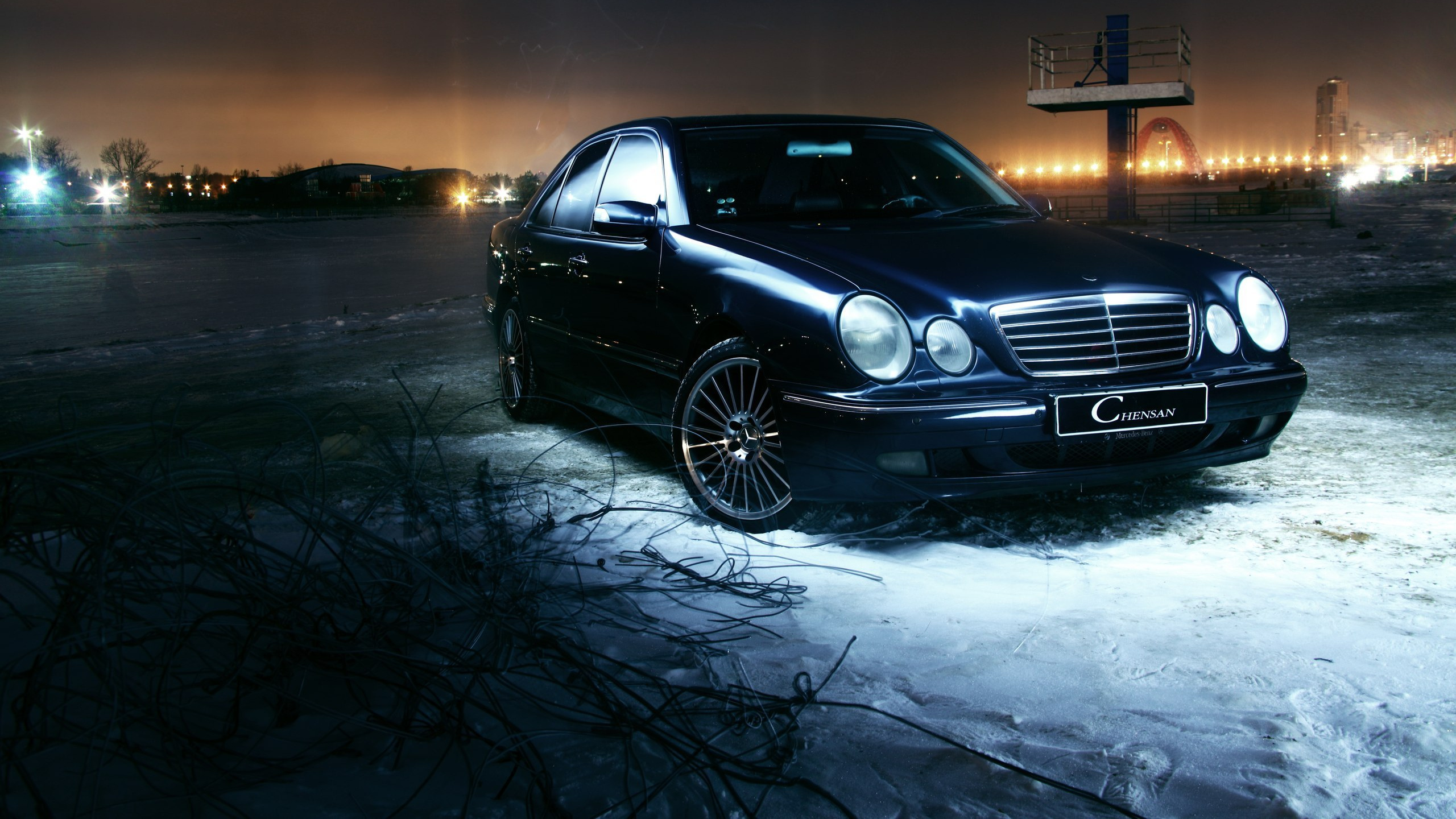 Schwarzes Mercedes-benz-coupé Auf Schneebedecktem Boden Während Der Nachtzeit. Wallpaper in 2560x1440 Resolution