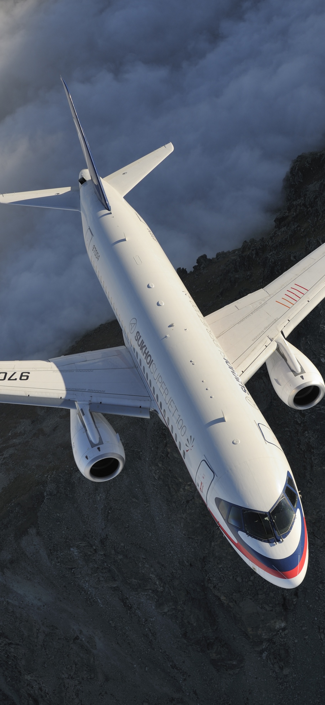 Avion Blanc et Rouge Survolant la Montagne. Wallpaper in 1125x2436 Resolution