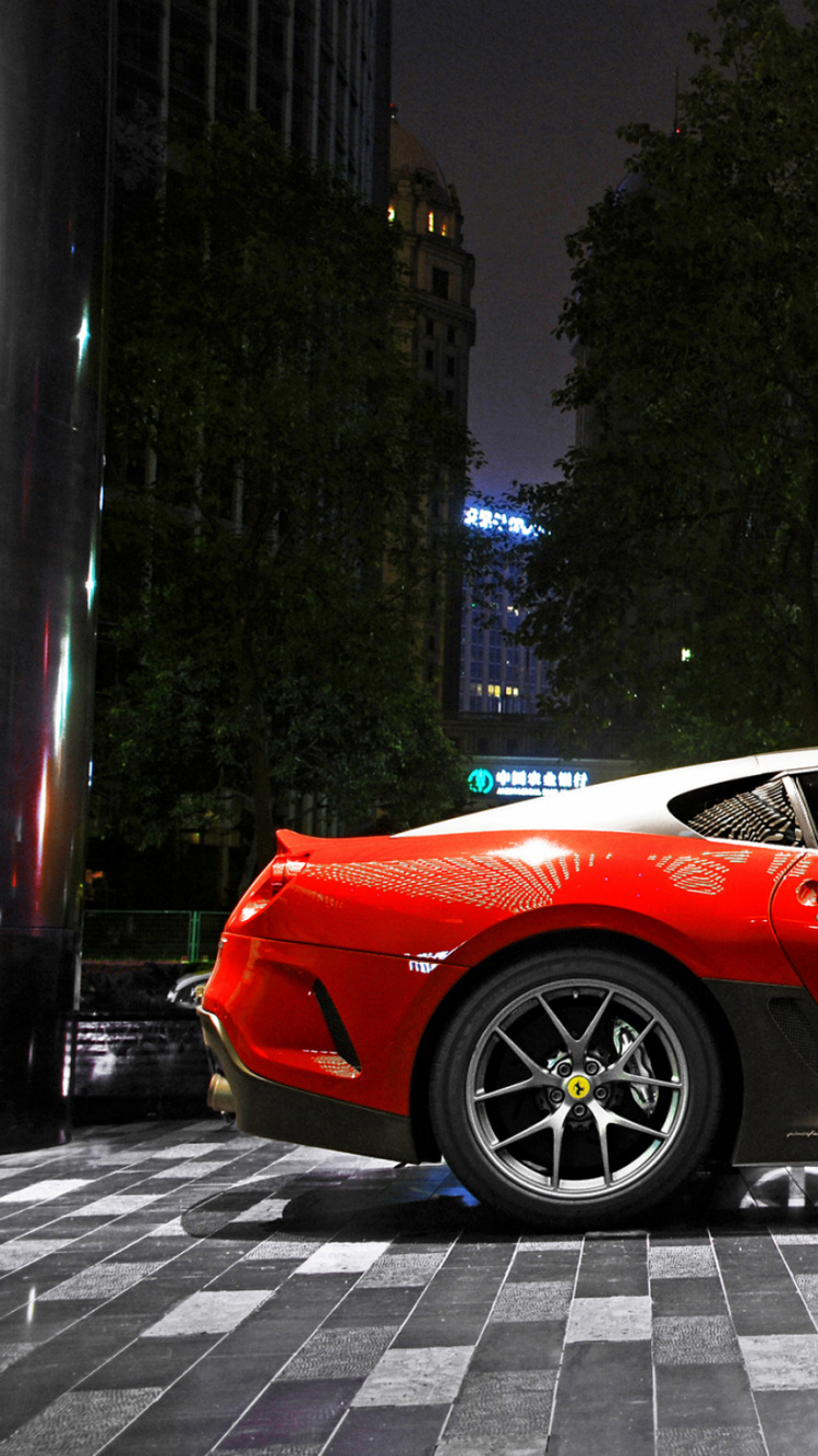 Red Ferrari 458 Italia Parked Near Green Trees During Night Time. Wallpaper in 750x1334 Resolution