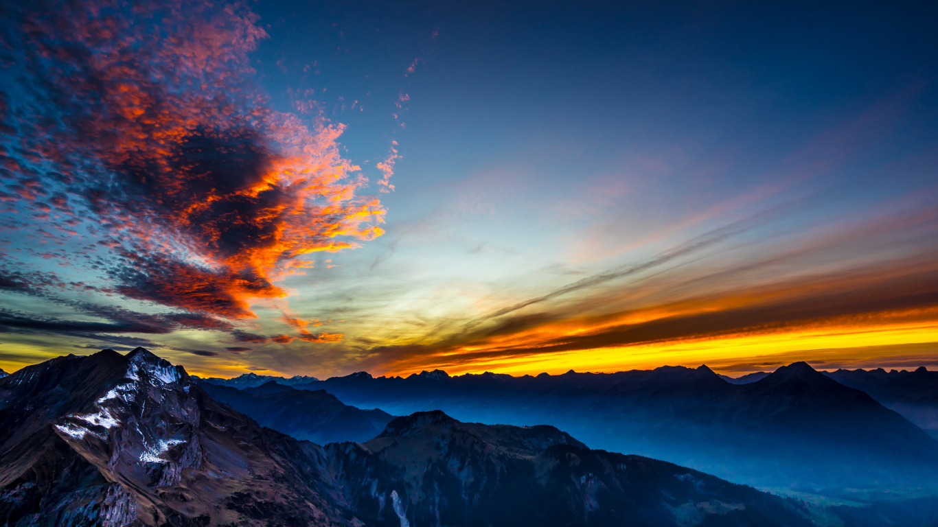 Schneebedeckter Berg Unter Orangefarbenem Und Blauem Himmel. Wallpaper in 1366x768 Resolution