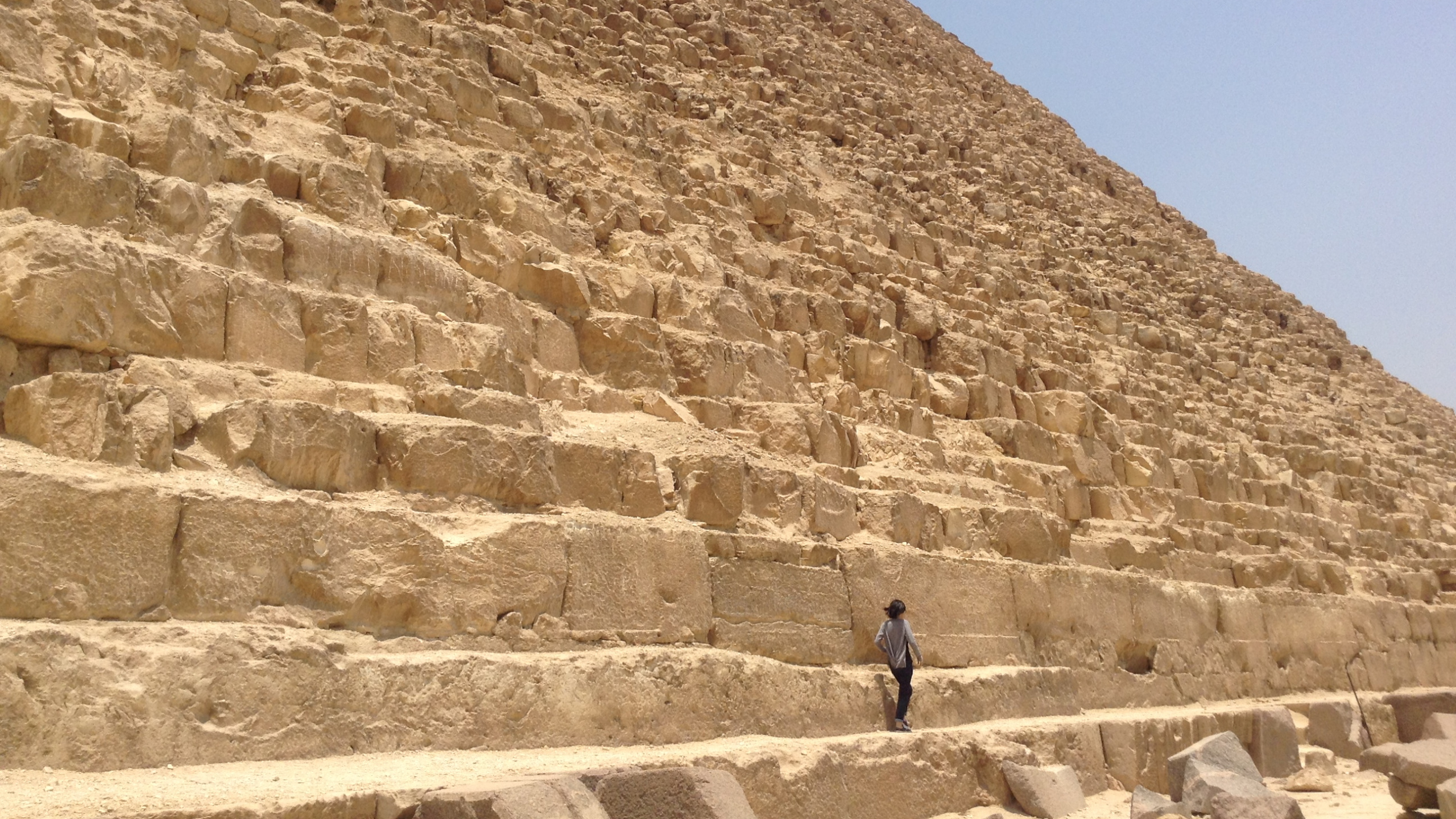 L'homme en Veste Noire Debout Sur Brown Rock Formation Pendant la Journée. Wallpaper in 2560x1440 Resolution