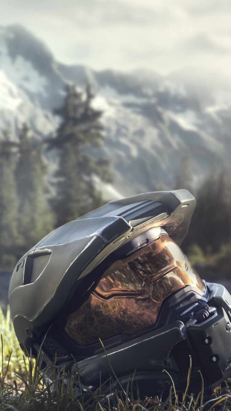 Schwarzer Und Grauer Helm Auf Grünem Gras Tagsüber. Wallpaper in 750x1334 Resolution