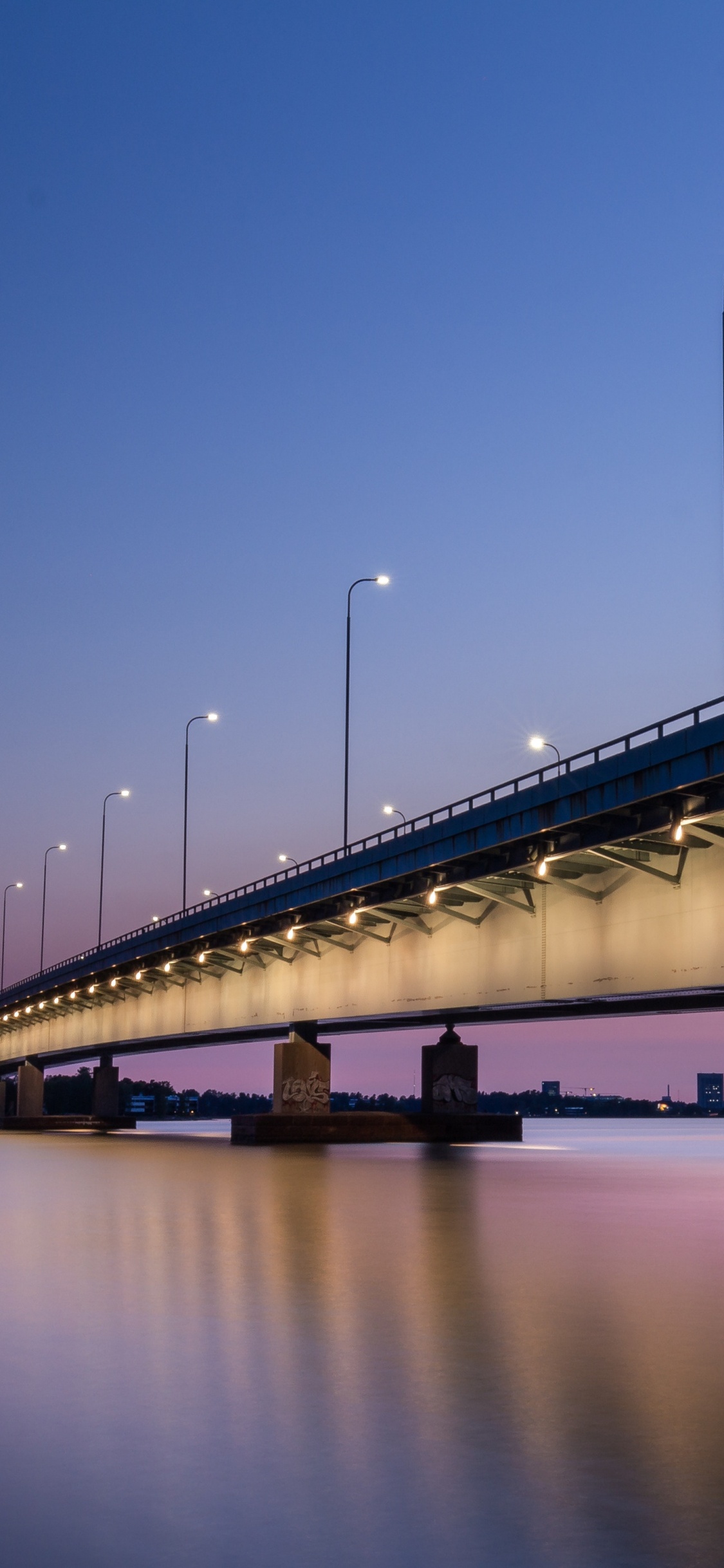 Puente Blanco Sobre el Agua Durante la Noche. Wallpaper in 1125x2436 Resolution