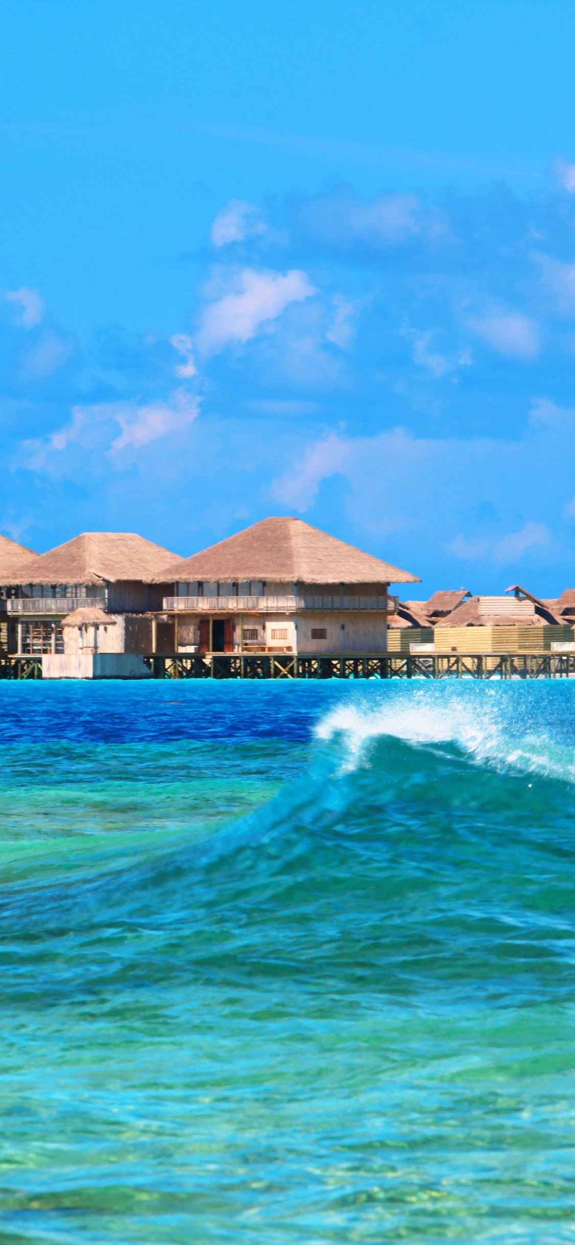 Brown and White Wooden Houses Near Body of Water Under Blue Sky During Daytime. Wallpaper in 1125x2436 Resolution