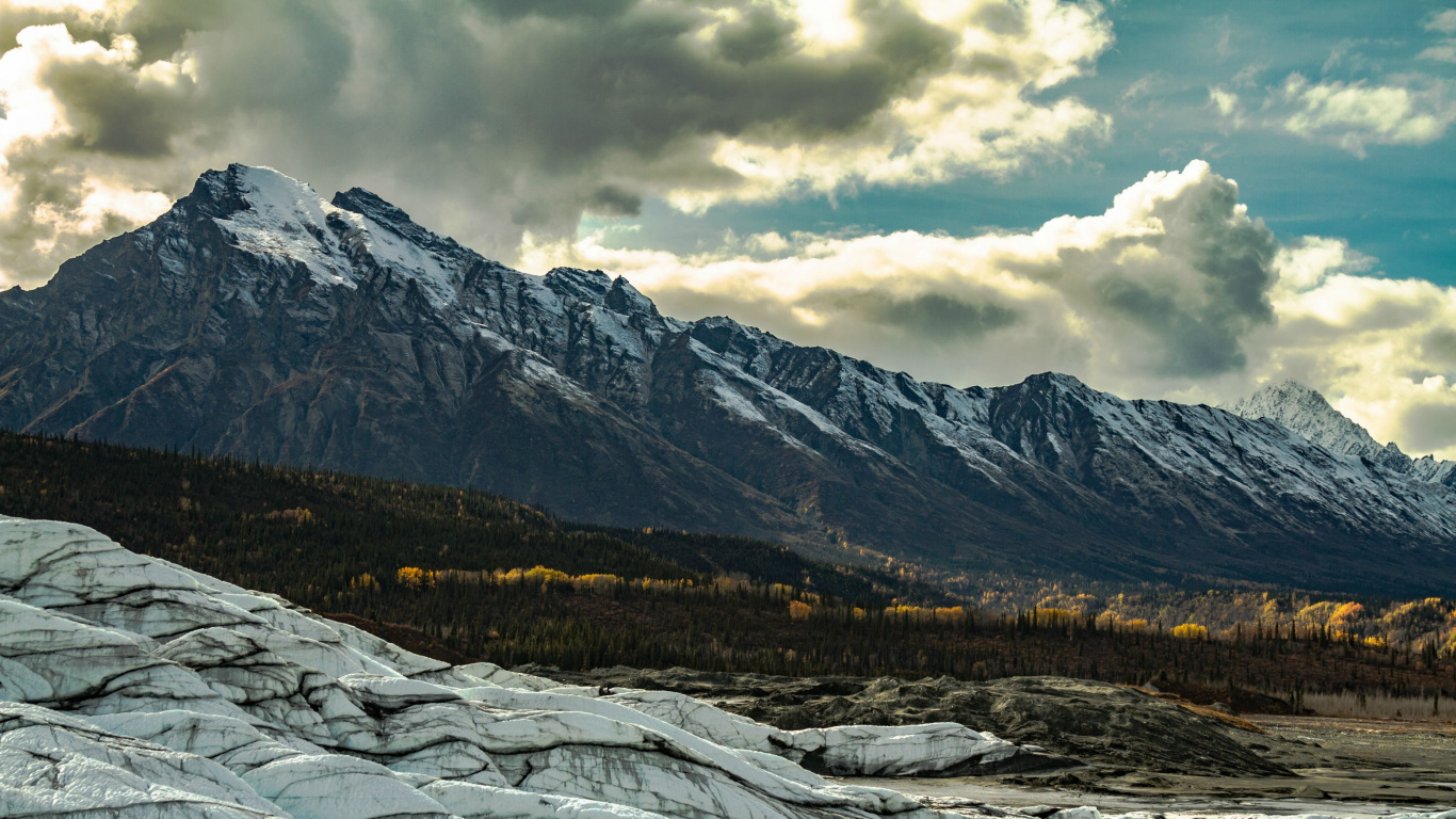 Snow Covered Field and Mountains Under Cloudy Sky During Daytime. Wallpaper in 1366x768 Resolution
