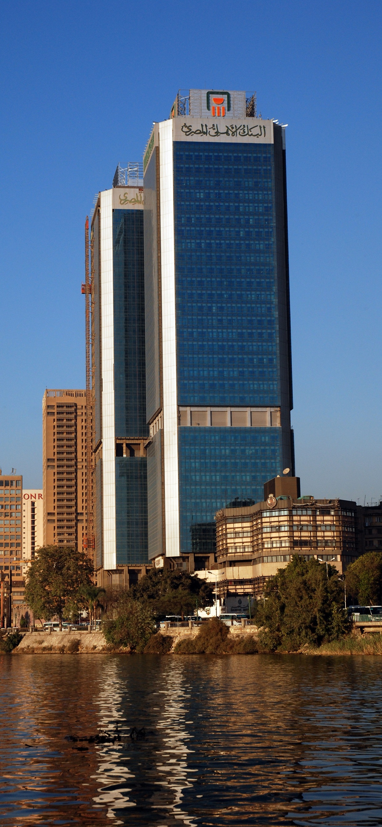 High Rise Building Near Body of Water During Daytime. Wallpaper in 1242x2688 Resolution