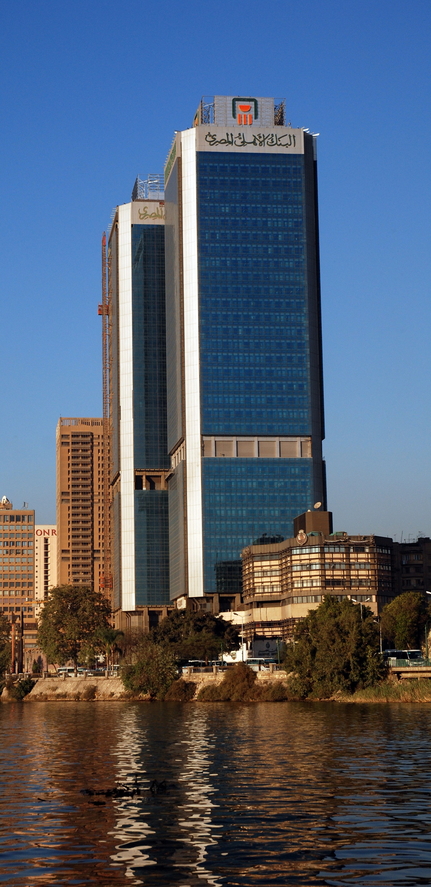 Hochhaus in Der Nähe Eines Gewässers Tagsüber. Wallpaper in 1440x2960 Resolution