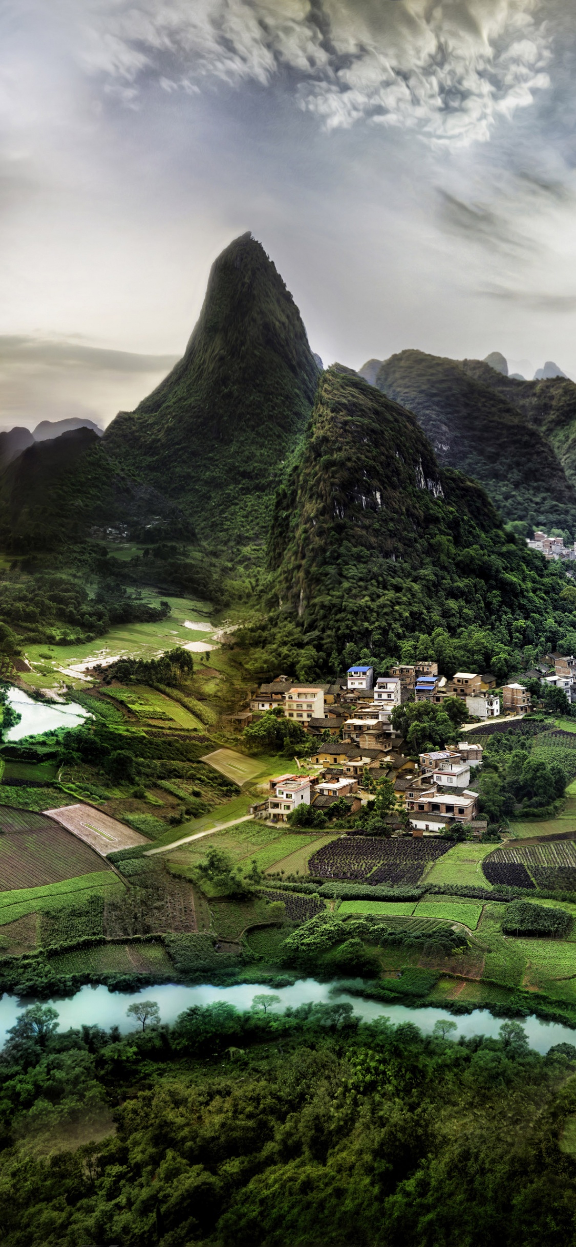 Green and Black Mountain Under Cloudy Sky During Daytime. Wallpaper in 1125x2436 Resolution