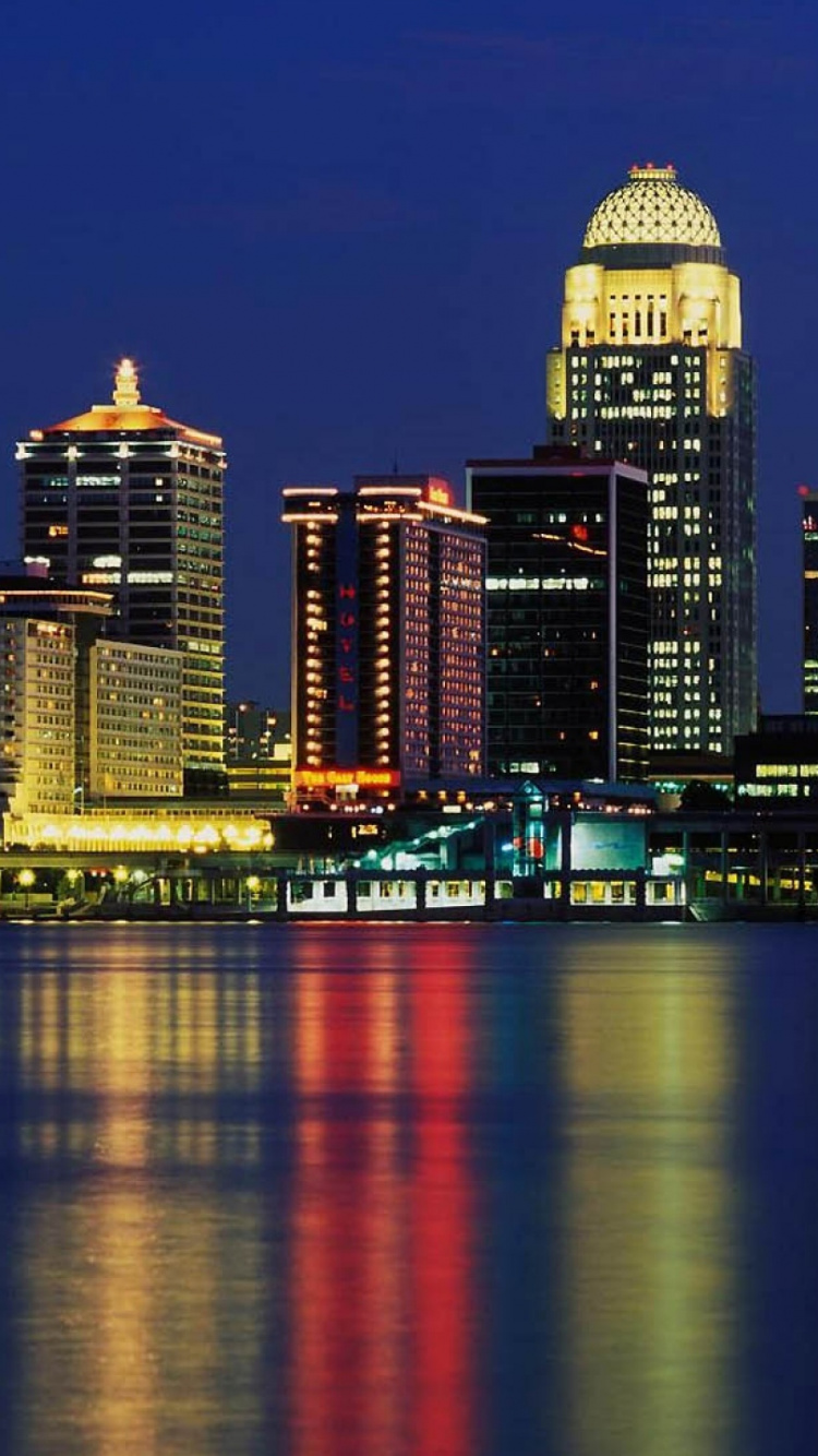 Skyline Der Stadt Über Gewässer Während Der Nacht. Wallpaper in 750x1334 Resolution