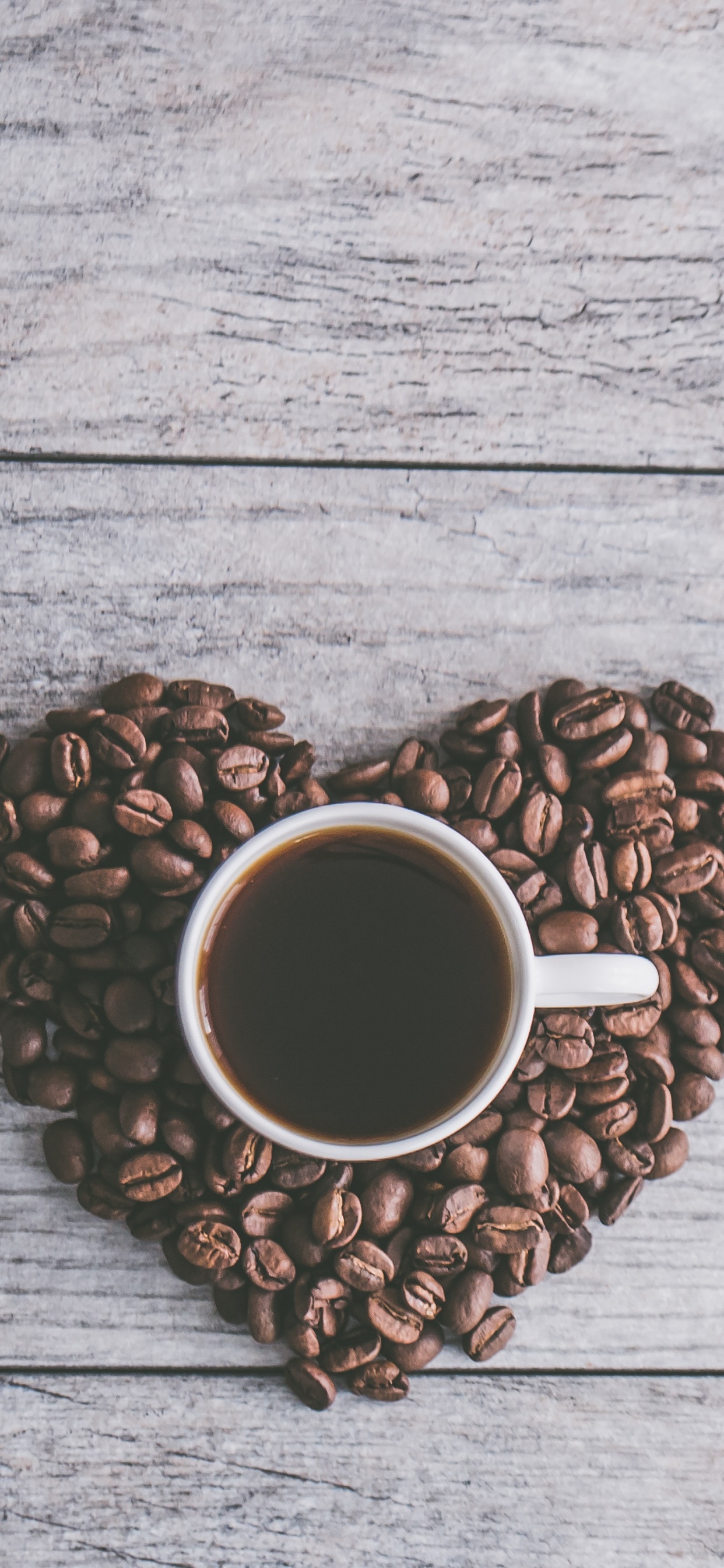 Weiße Keramiktasse Auf Braunen Kaffeebohnen. Wallpaper in 1242x2688 Resolution