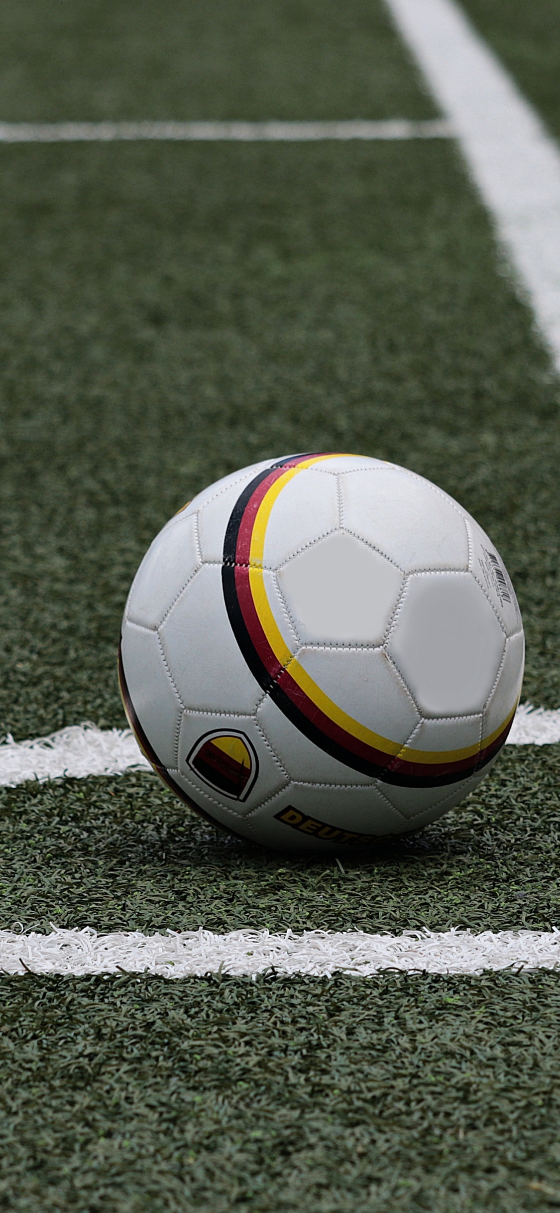 Ballon de Football Blanc et Jaune Sur Champ Vert. Wallpaper in 1125x2436 Resolution