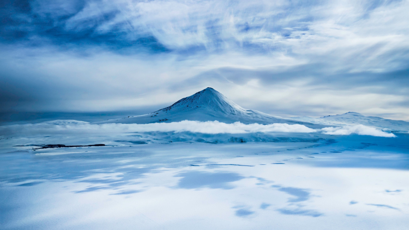 Montagne Couverte de Neige Sous un Ciel Nuageux Pendant la Journée. Wallpaper in 1366x768 Resolution