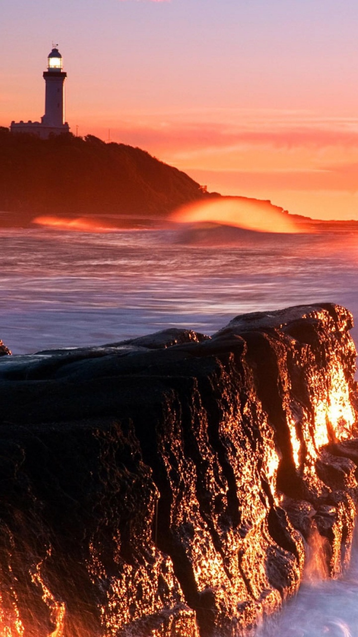 Silhouette of Person Standing on Rock Formation Near Sea During Sunset. Wallpaper in 720x1280 Resolution