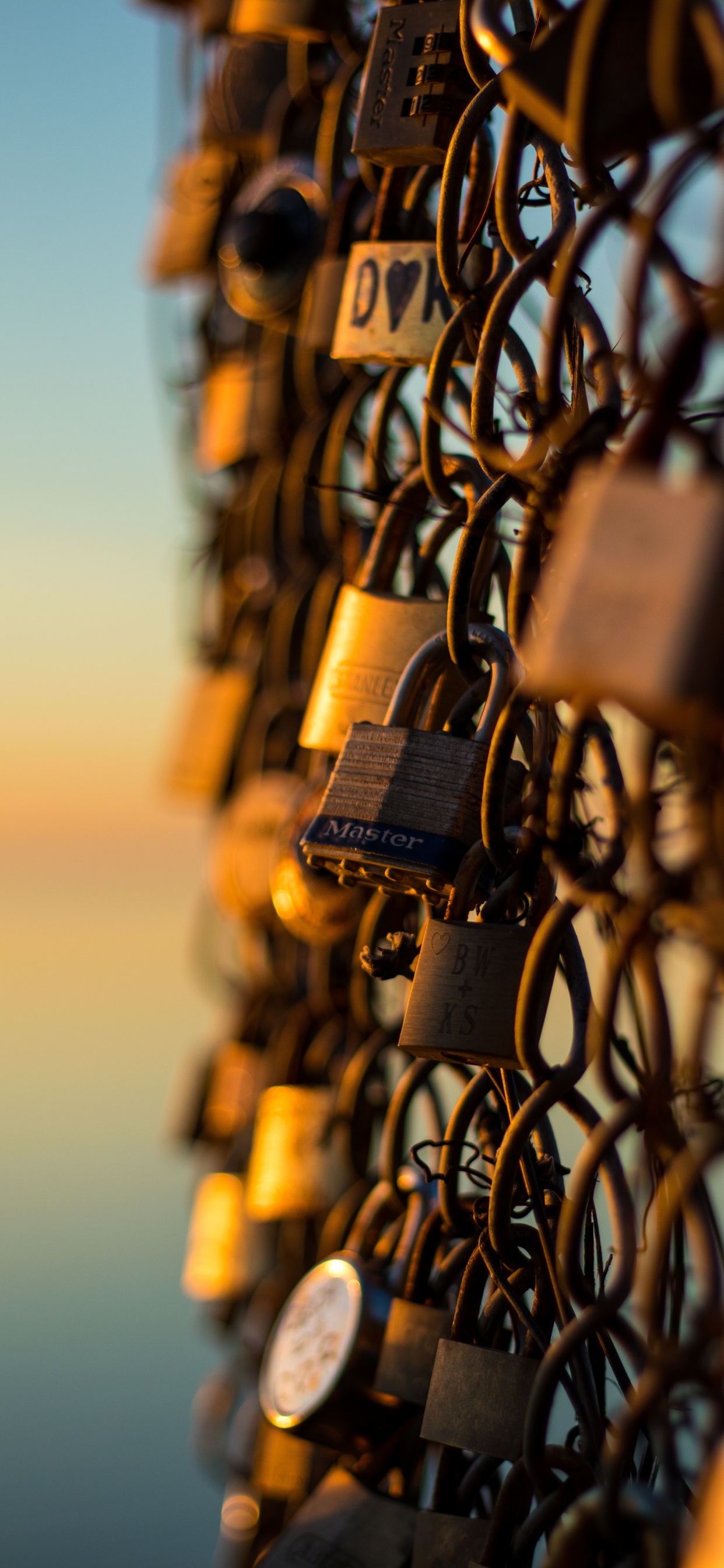 Padlock on Chain Link Fence During Sunset. Wallpaper in 1242x2688 Resolution