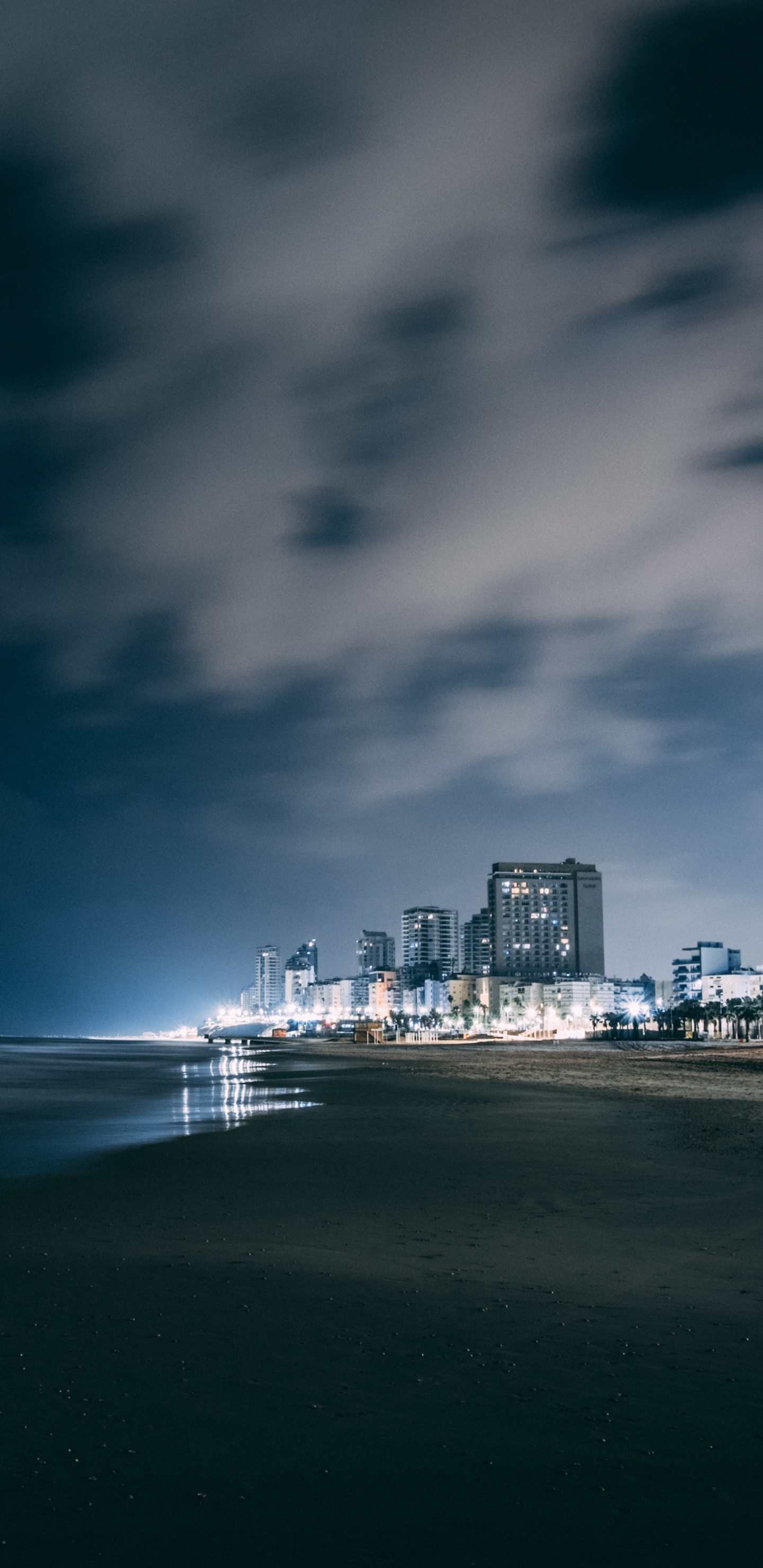 Skyline Der Stadt Über Gewässer Während Der Nacht. Wallpaper in 1440x2960 Resolution
