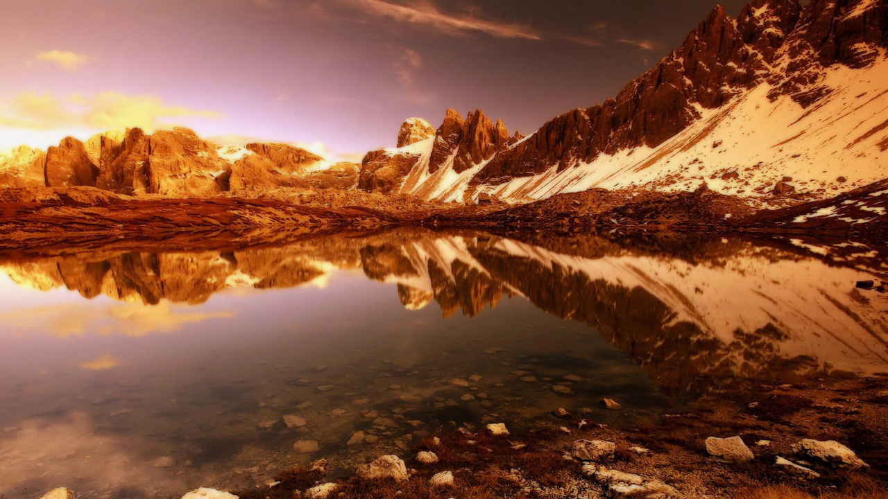 Montañas Marrones y Blancas Cerca Del Lago Bajo un Cielo Azul Durante el Día. Wallpaper in 1280x720 Resolution