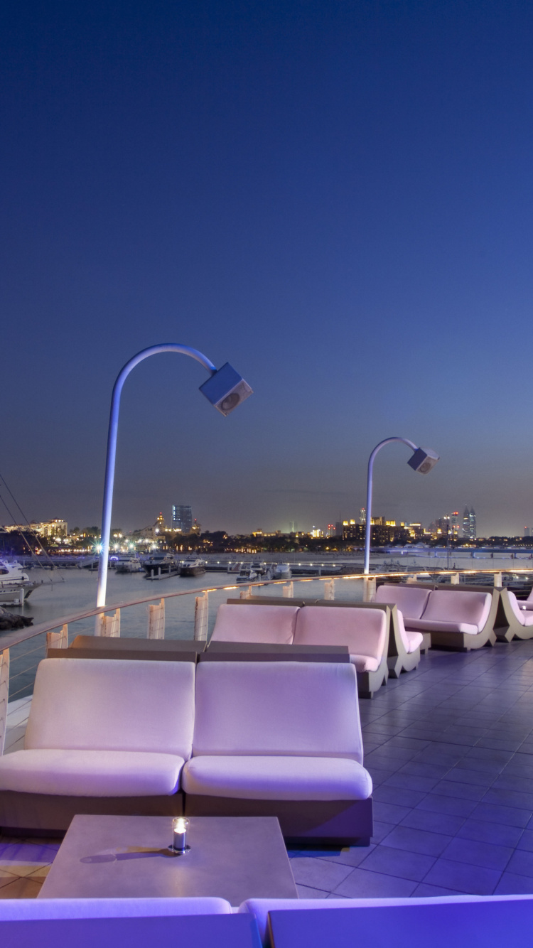 Bâtiment en Béton Blanc et Gris Près D'un Plan D'eau Pendant la Nuit. Wallpaper in 750x1334 Resolution