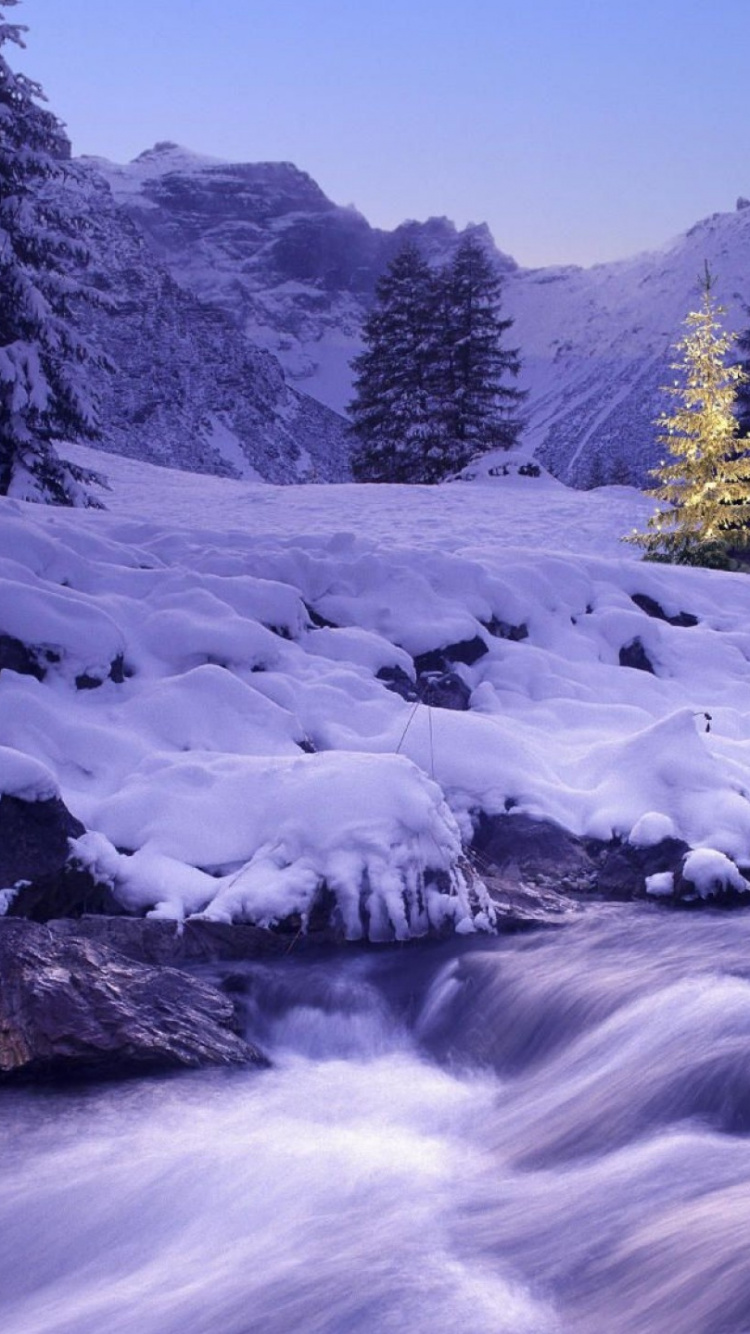 Schneebedeckter Fluss in Der Nähe Von Grünen Bäumen Und Schneebedeckten Bergen Tagsüber. Wallpaper in 750x1334 Resolution