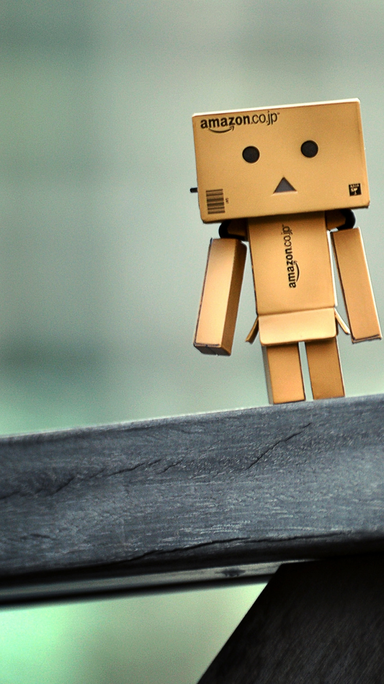 Brauner Karton Auf Schwarzem Holzzaun. Wallpaper in 750x1334 Resolution