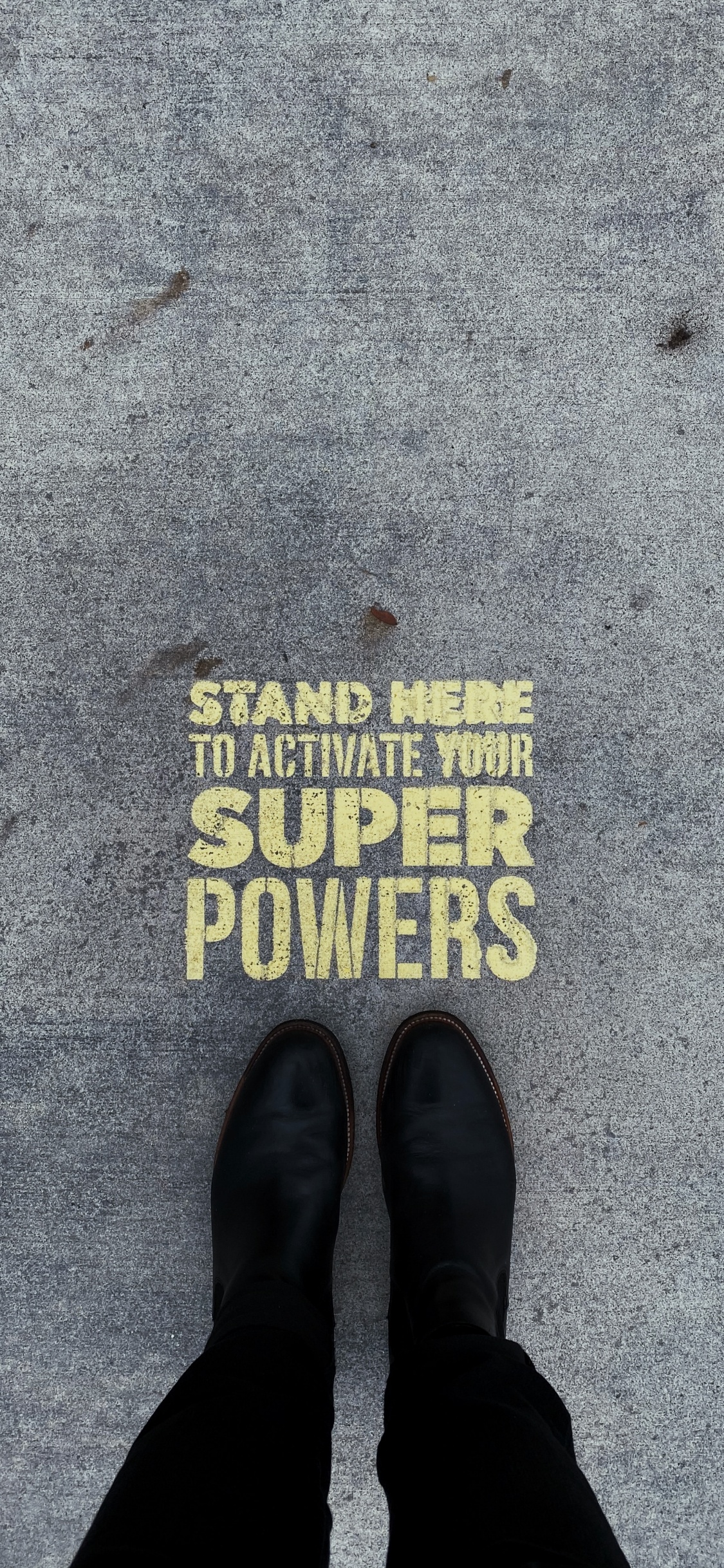 Personne Portant Des Chaussures en Cuir Noir Debout Sur un Sol en Béton Gris. Wallpaper in 1125x2436 Resolution